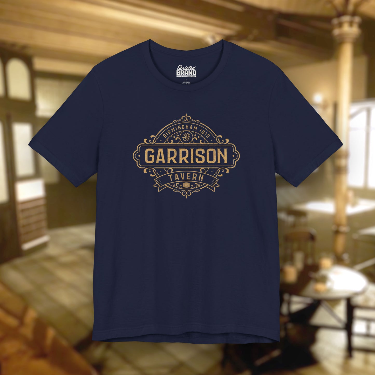 Front view of a navy blue soft Bella+Canvas 3001 short-sleeve t-shirt featuring the Garrison Tavern Bar Logo Graphic inspired by the TV show and movie Peaky Blinders in a vintage distressed style, sold by ScriptedBrand.