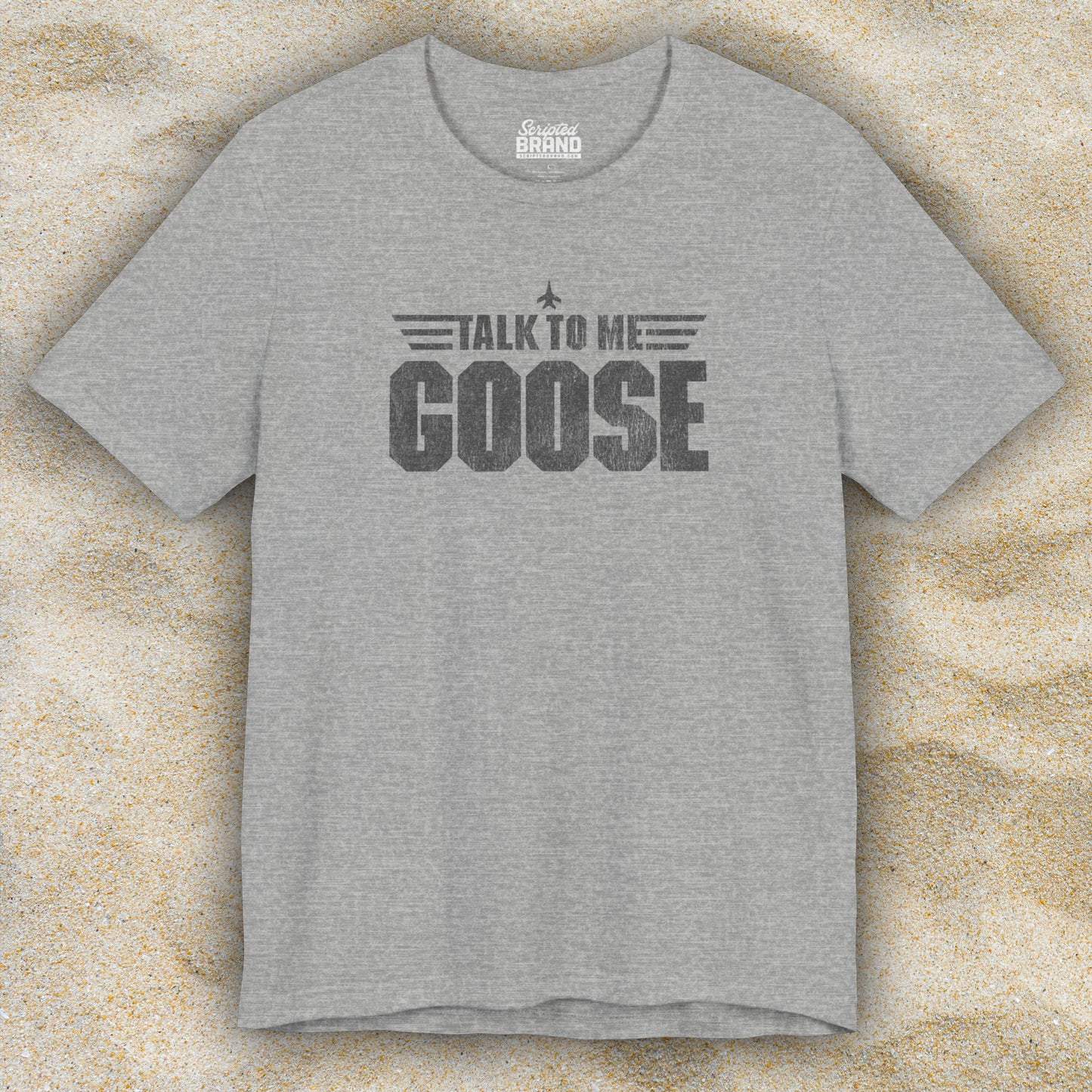 Front view of an athletic heather grey soft unisex Bella+Canvas 3001 short-sleeve t-shirt featuring a graphic designed by ScriptedBrand in a vintage distressed style with the text TALK TO ME GOOSE, inspired by the Movie Top Gun.