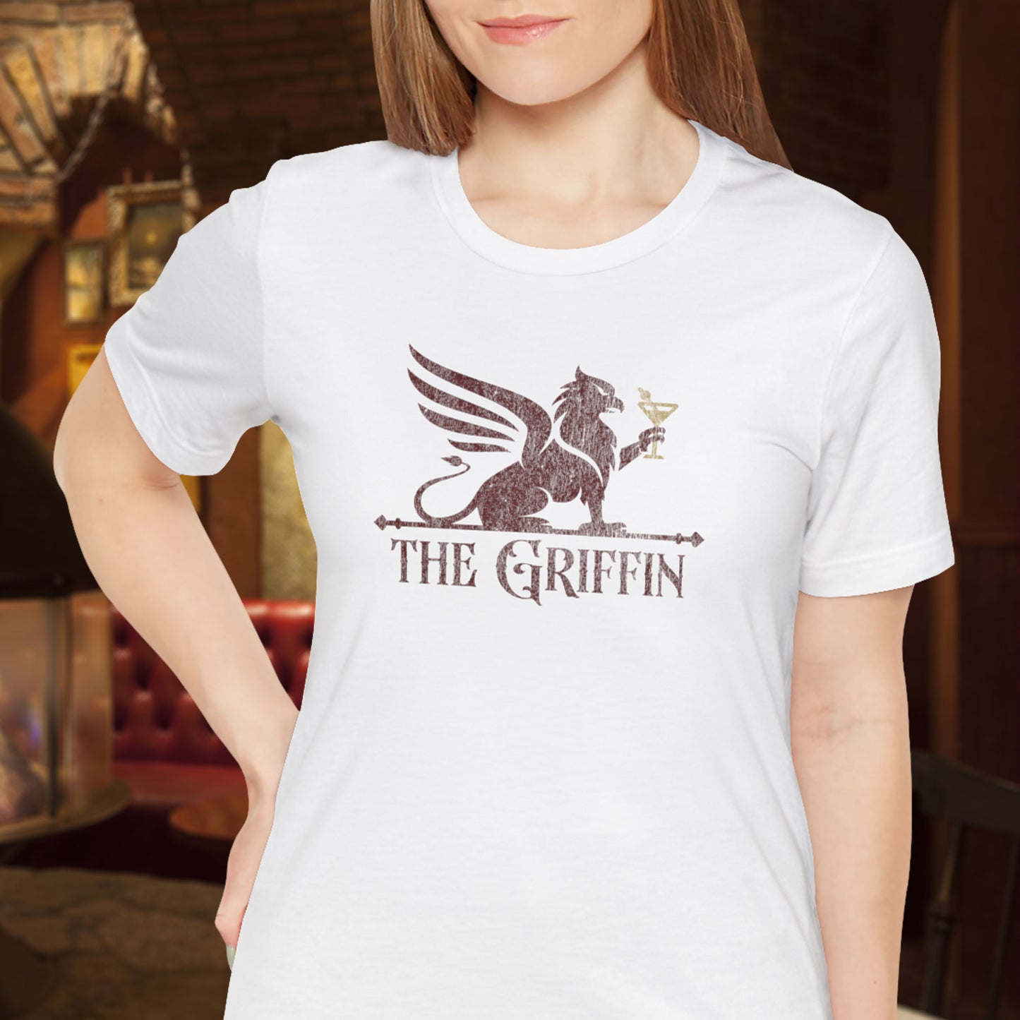 Woman wearing white t-shirt featuring maroon 'The Griffin' Bar logo inspired by the TV show New Girl in a vintage distressed style.