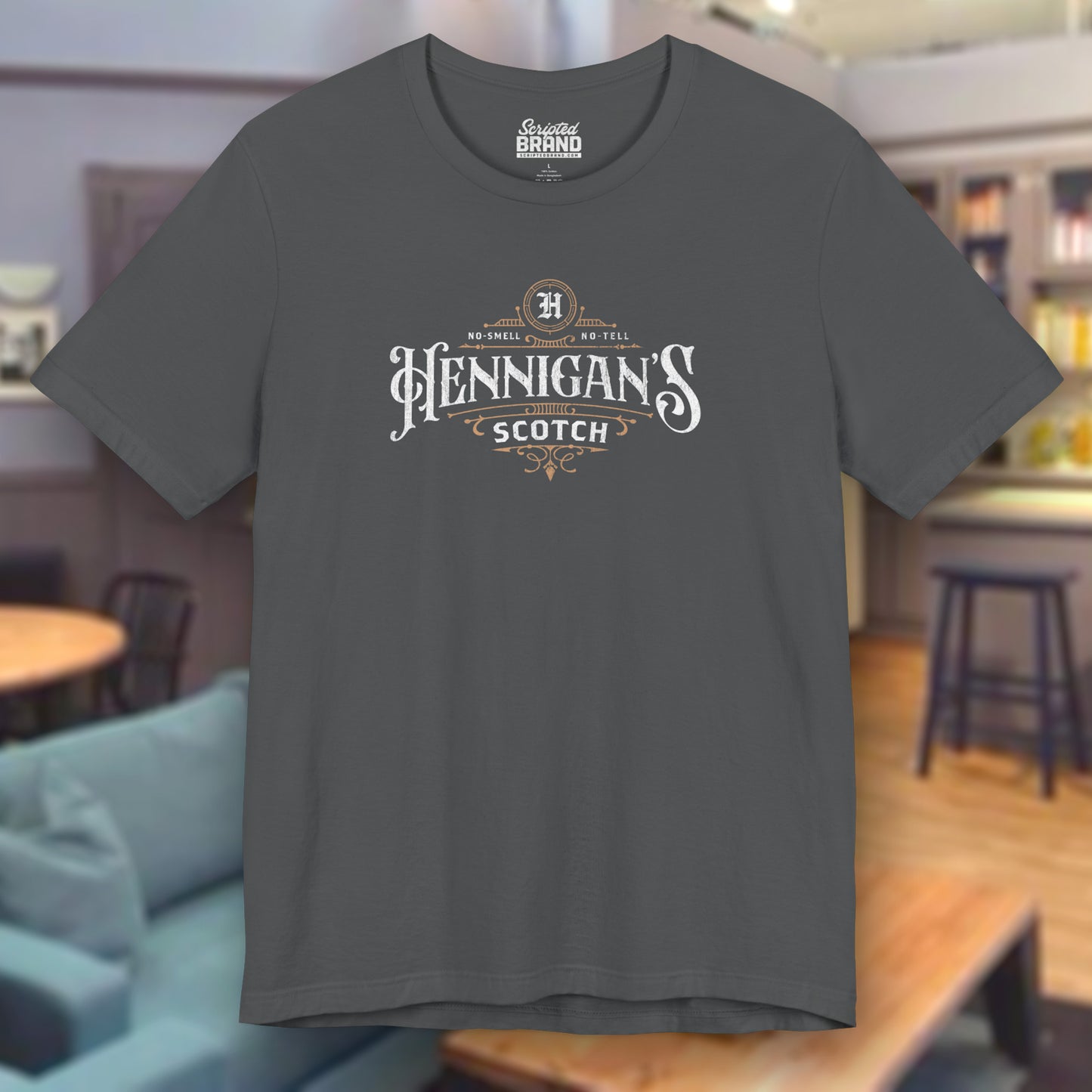 Asphalt gray colored soft short-sleeve t-shirt featuring a Hennigans Scotch Whisky logo graphic inspired by the TV show Seinfeld in a vintage distressed ink-stamped worn-in style.