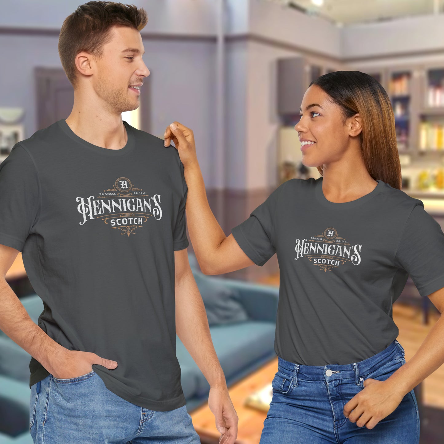 2 models wearing asphalt gray colored soft short-sleeve t-shirts featuring a Hennigans Scotch Whisky logo graphic inspired by the TV show Seinfeld in a vintage distressed ink-stamped worn-in style.