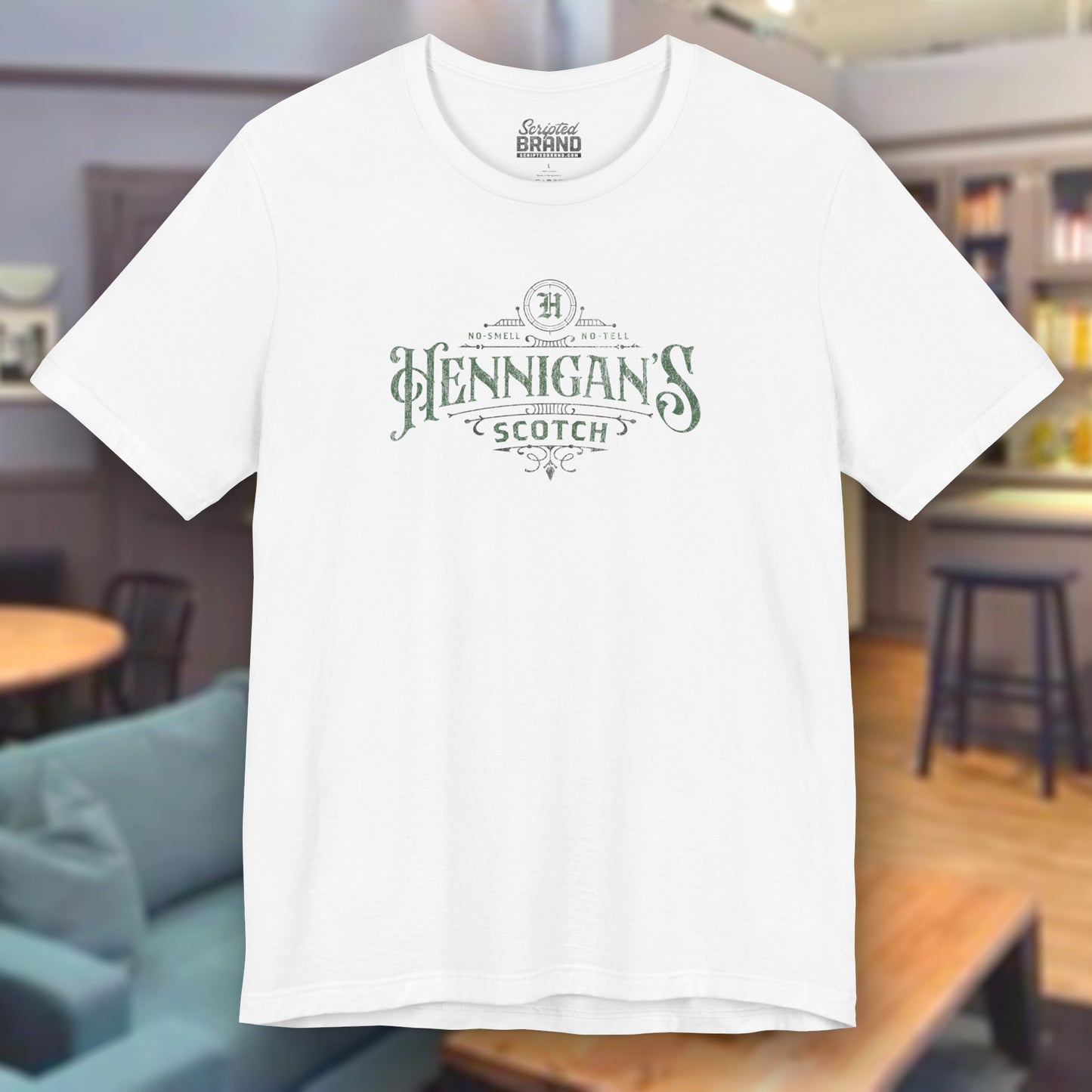 White colored soft short-sleeve t-shirt featuring a Hennigans Scotch Whisky logo graphic inspired by the TV show Seinfeld in a vintage distressed ink-stamped worn-in style.