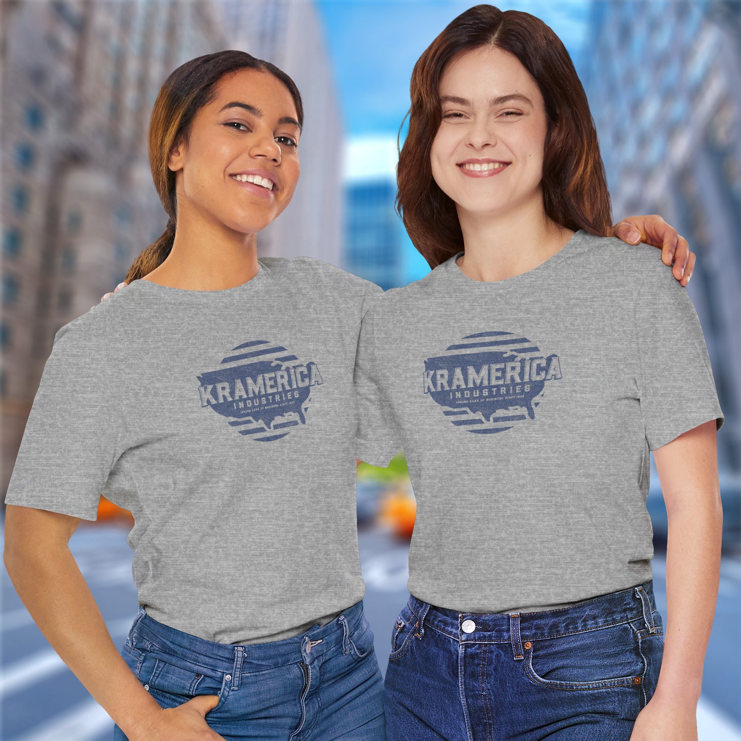 2 female models wearing athletic heather grey soft unisex Bella+Canvas 3001 short-sleeve t-shirts featuring a unique Kramerica Industries logo graphic, designed by ScriptedBrand in a vintage distressed style, and inspired by the TV show Seinfeld.
