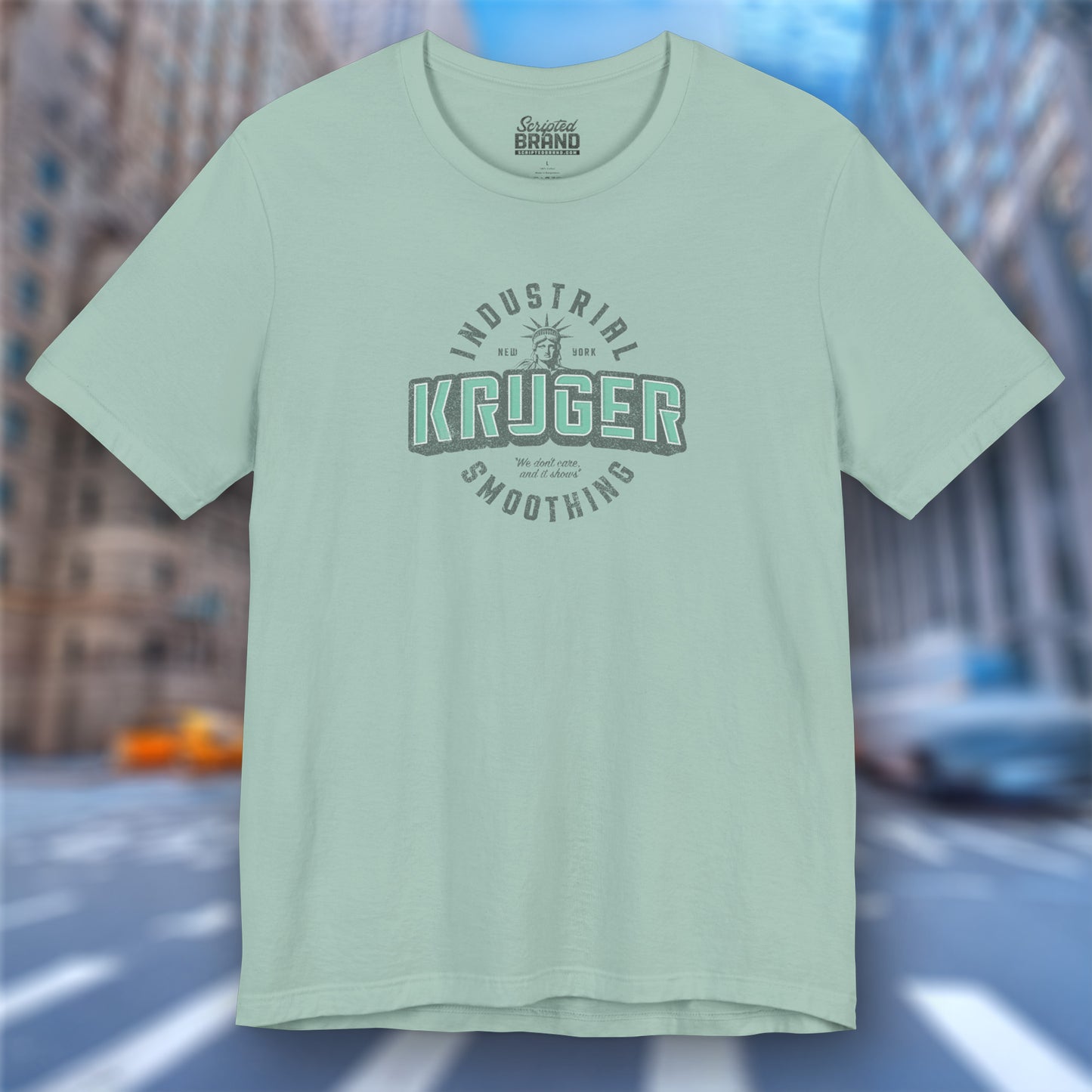 Front view of a dusty blue colored Soft unisex Bella+Canvas 3001 short-sleeve t-shirt featuring a Kruger Industrial Smoothing logo graphic in a vintage distressed style, designed by ScriptedBrand, and inspired by the TV show Seinfeld.