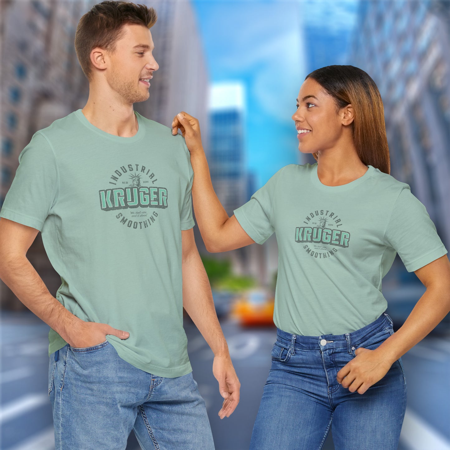 2 models wearing dusty blue colored Soft unisex Bella+Canvas 3001 short-sleeve t-shirt featuring a Kruger Industrial Smoothing logo graphic in a vintage distressed style, designed by ScriptedBrand, and inspired by the TV show Seinfeld.
