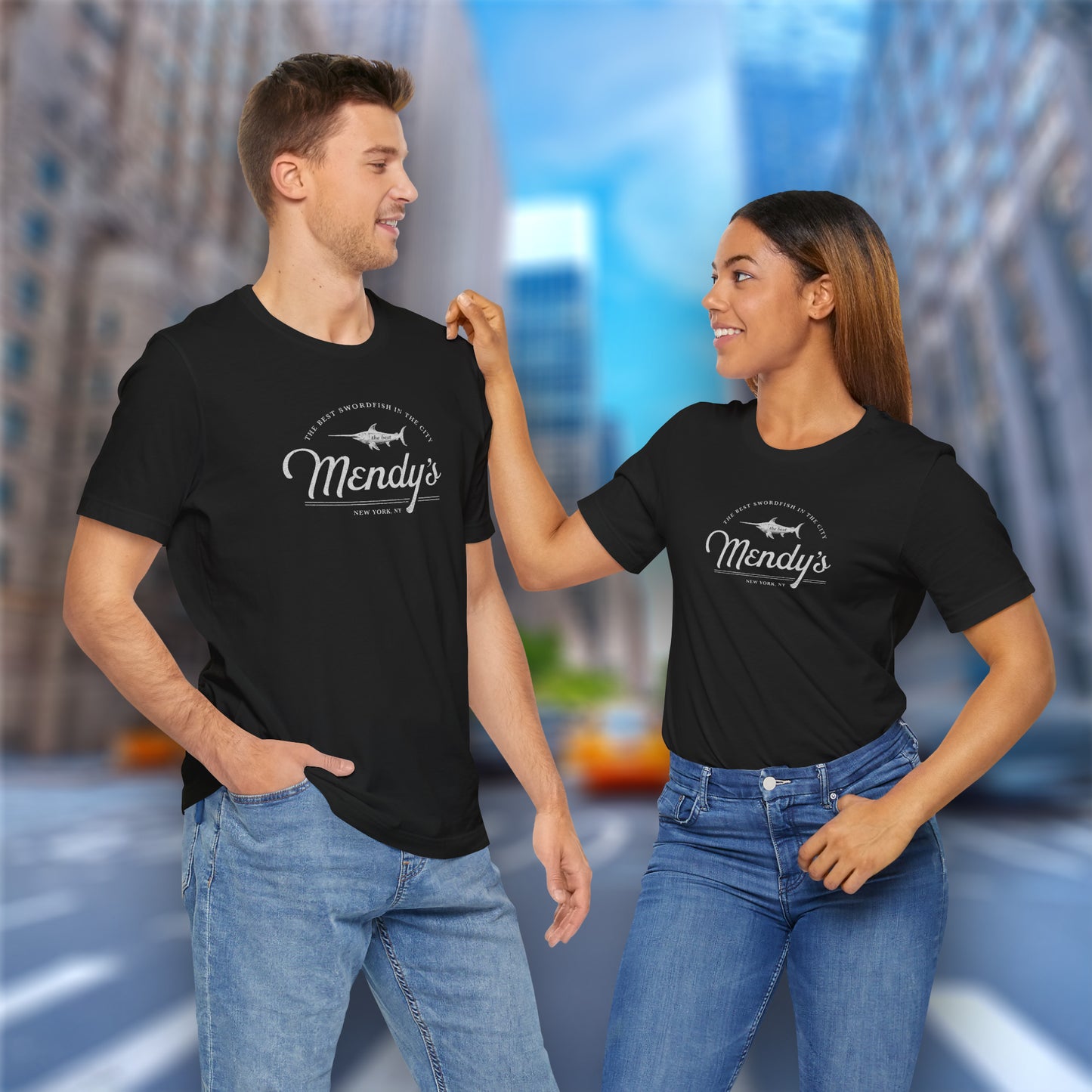 2 models wearing black colored soft unisex Bella+Canvas 3001 short-sleeve t-shirts featuring a unique Mendy's Restaurant logo graphic, designed by ScriptedBrand in a vintage distressed style, and inspired by the TV show Seinfeld.