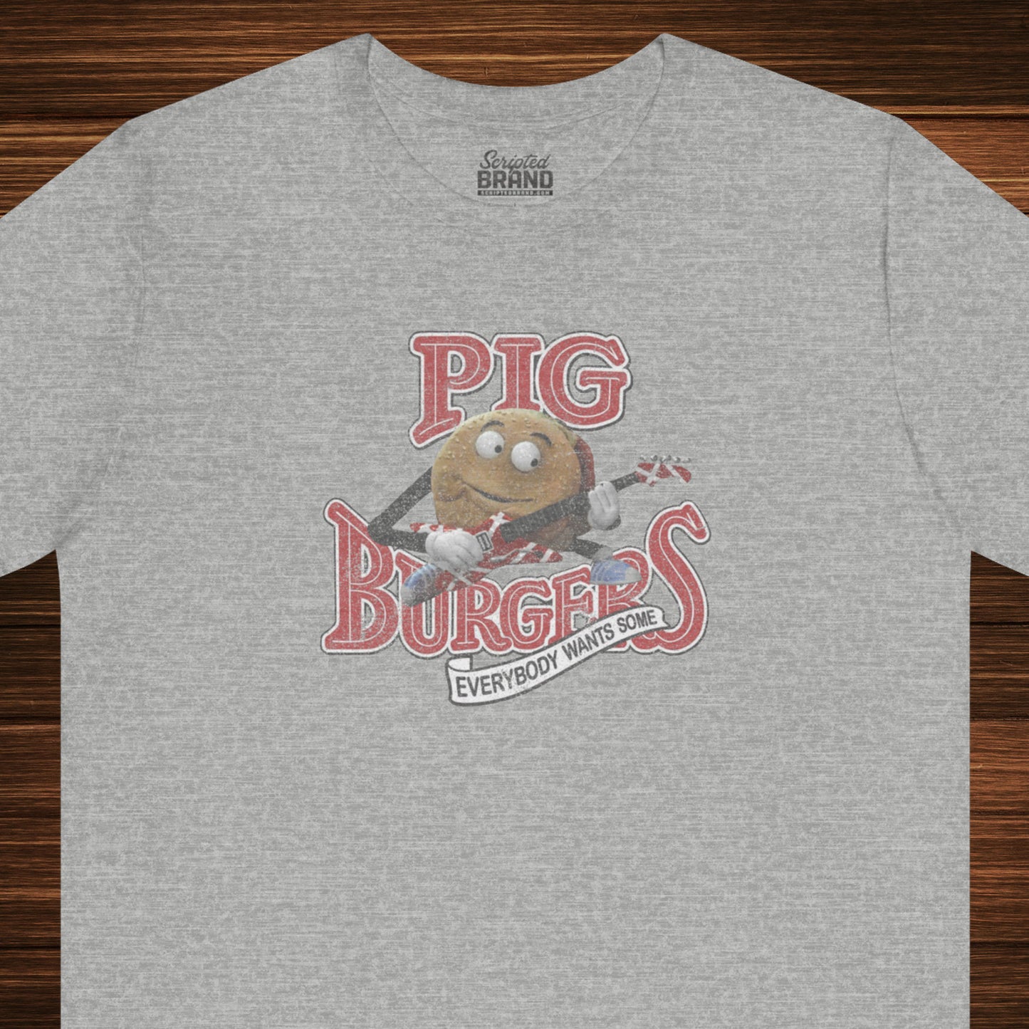 Front view of an athletic heather grey colored soft Bella+Canvas 3001 short-sleeve t-shirt featuring a graphic of the fictional Pig Burgers logo from the movie Better Off Dead, along with the Van Halen singing hamburger playing guitar, with the small subhead phrase EVERYBODY WANTS SOME. The graphic is designed in a vintage distressed style, sold by ScriptedBrand.