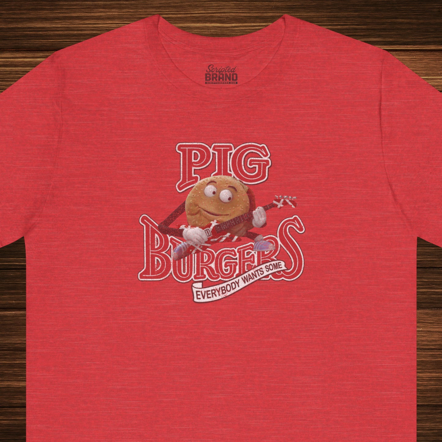 Front view of a heather red colored soft Bella+Canvas 3001 short-sleeve t-shirt featuring a graphic of the fictional Pig Burgers logo from the movie Better Off Dead, along with the Van Halen singing hamburger playing guitar, with the small subhead phrase EVERYBODY WANTS SOME. The graphic is designed in a vintage distressed style, sold by ScriptedBrand.
