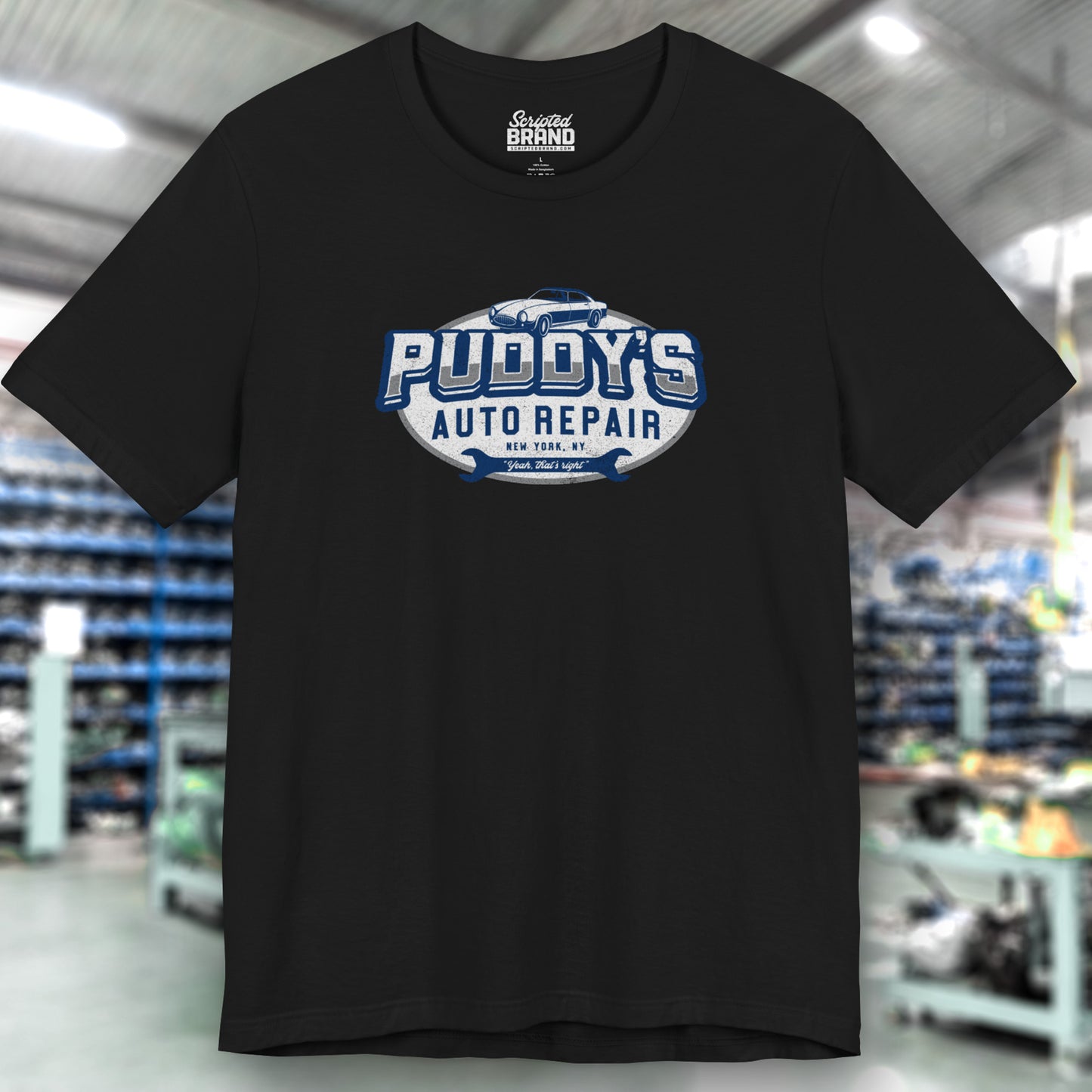 Front view of a black soft short-sleeve t-shirt featuring a Puddy's Auto Repair graphic designed by ScriptedBrand inspired by the TV show Seinfeld in a vintage distressed ink-stamped worn-in style.