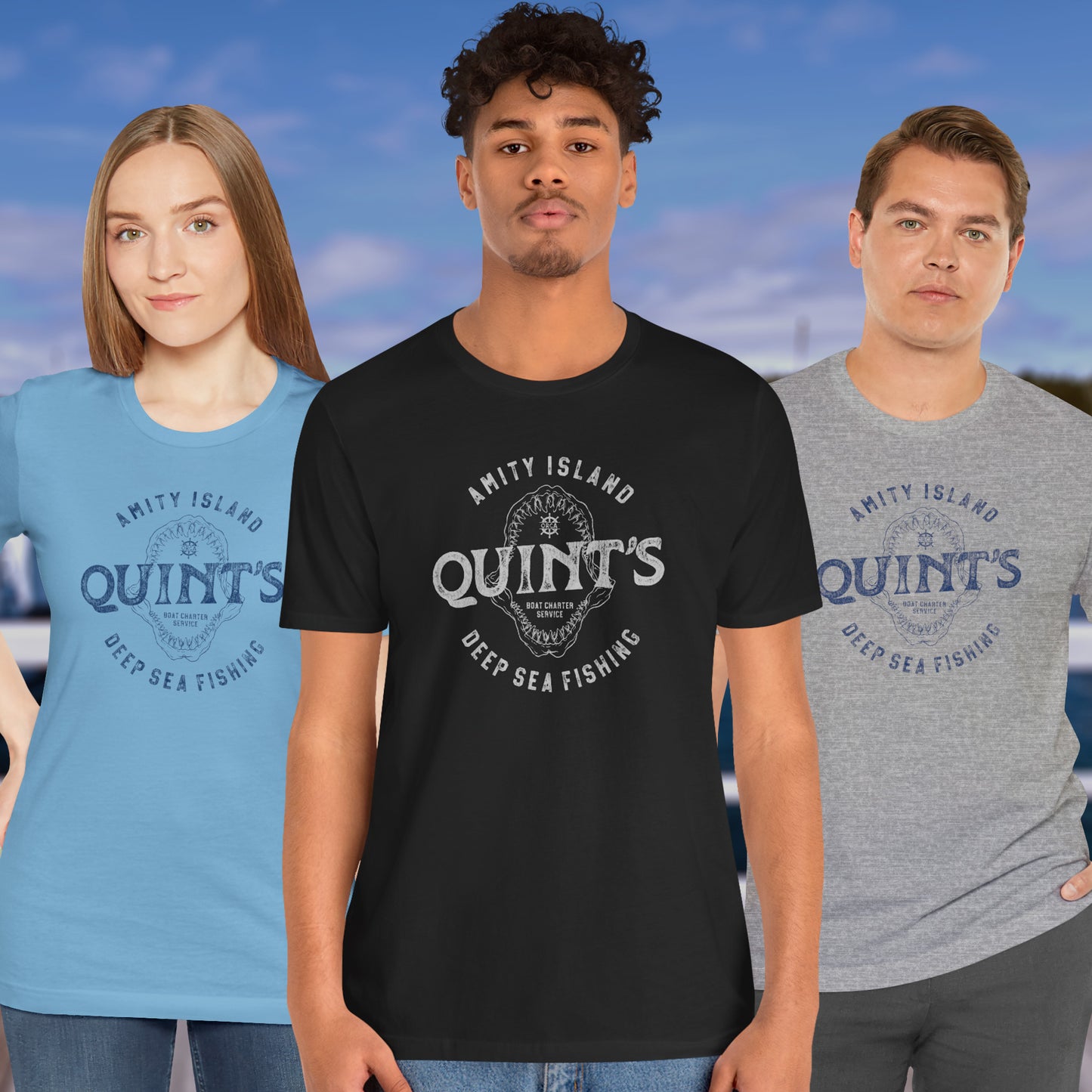 3 models wearing Soft short-sleeve t-shirts featuring the Quint's Deep Sea Fishing Boat Charters logo graphic inspired by the movie Jaws in a vintage distressed ink-stamped worn-in style.