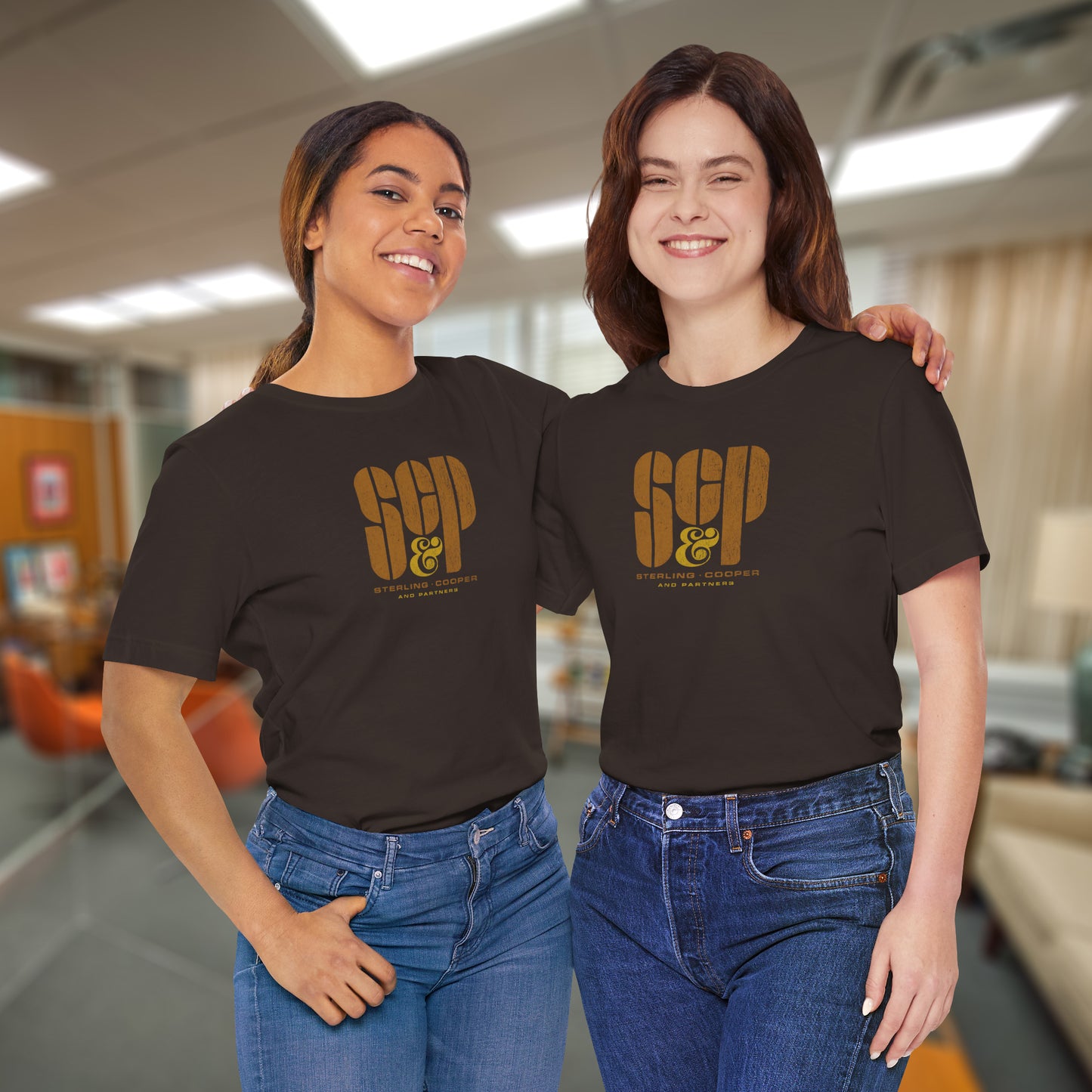 2 female models wearing brown colored soft unisex Bella+Canvas 3001 short-sleeve t-shirts featuring the Sterling Cooper & Partners logo graphic from the TV Show Mad Men in a vintage distressed style, sold by ScriptedBrand.
