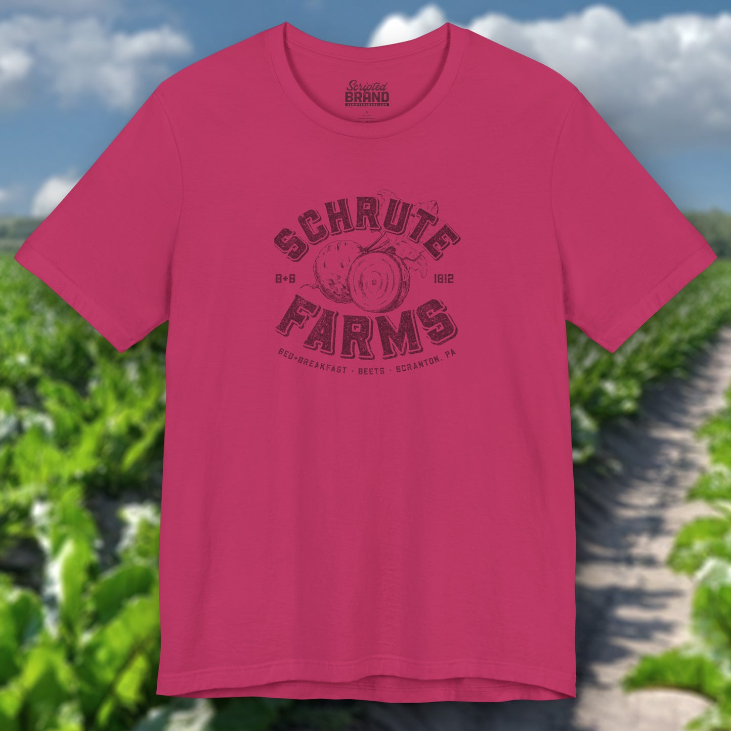 Berry red t-shirt featuring a Schrute Farms logo from the TV show The Office designed by ScriptedBrand in a vintage distressed style.