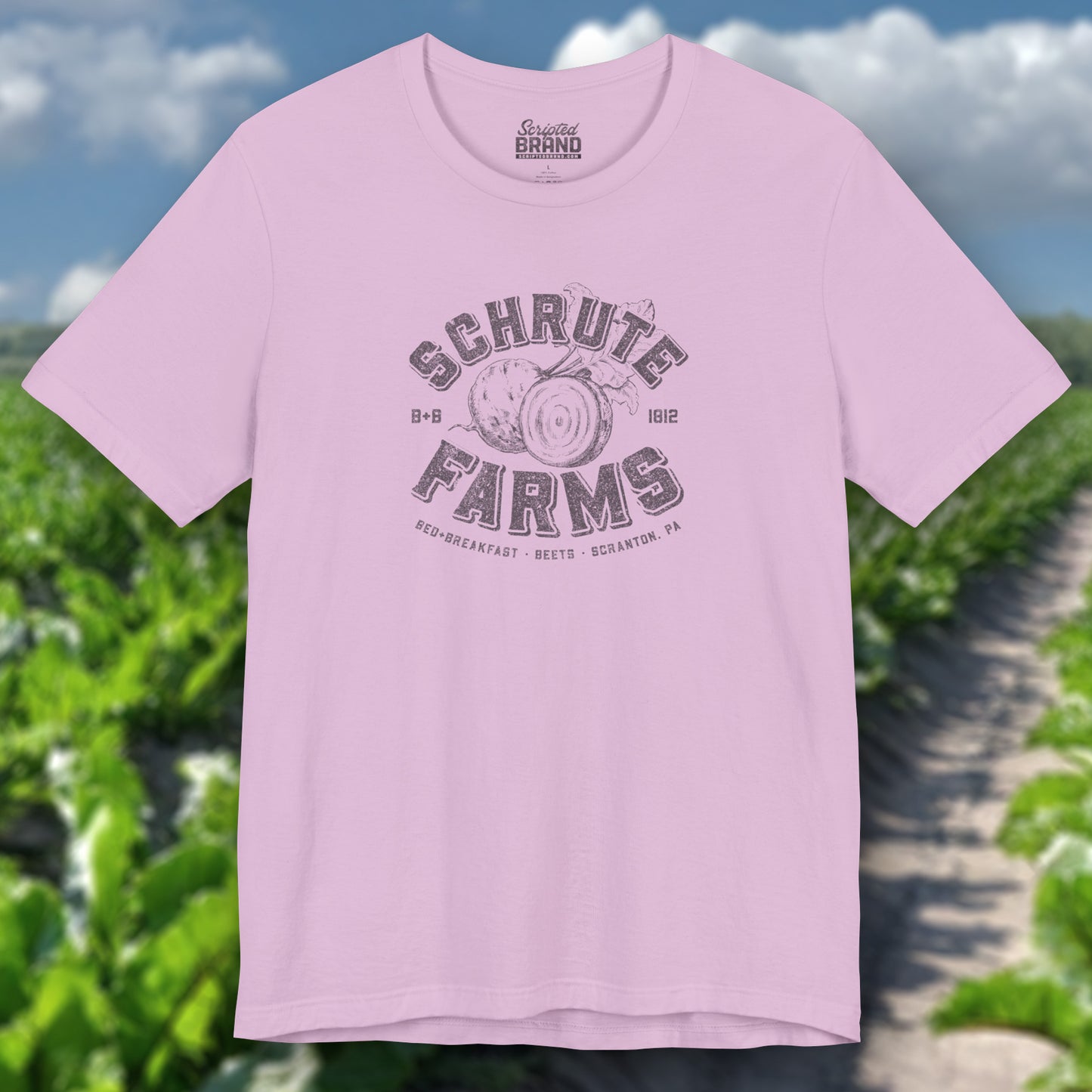 Lilac t-shirt featuring a Schrute Farms logo from the TV show The Office designed by ScriptedBrand in a vintage distressed style.