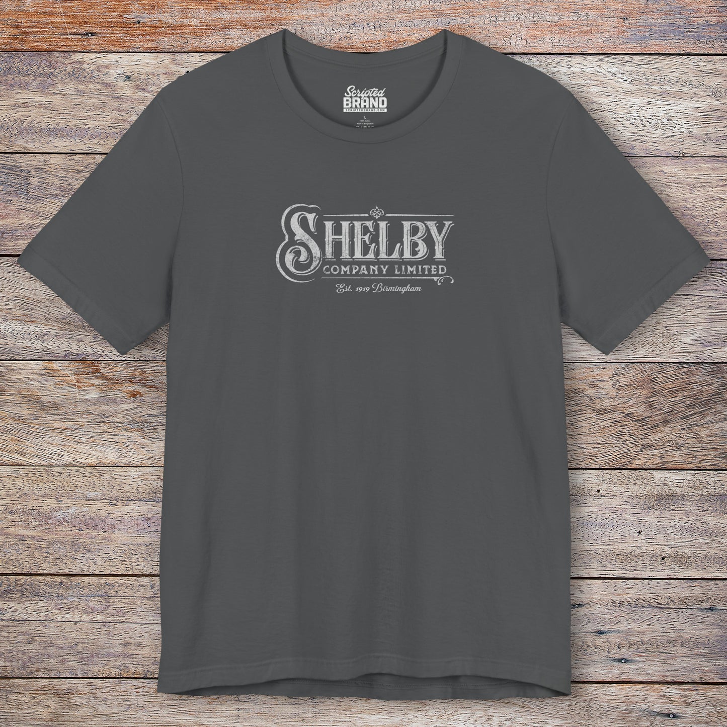 Front view of a asphalt gray soft short-sleeve Bella+Canvas 3001 t-shirt featuring the Shelby Company Limited logo from the show Peaky Blinders in a vintage distressed style, sold by ScriptedBrand.
