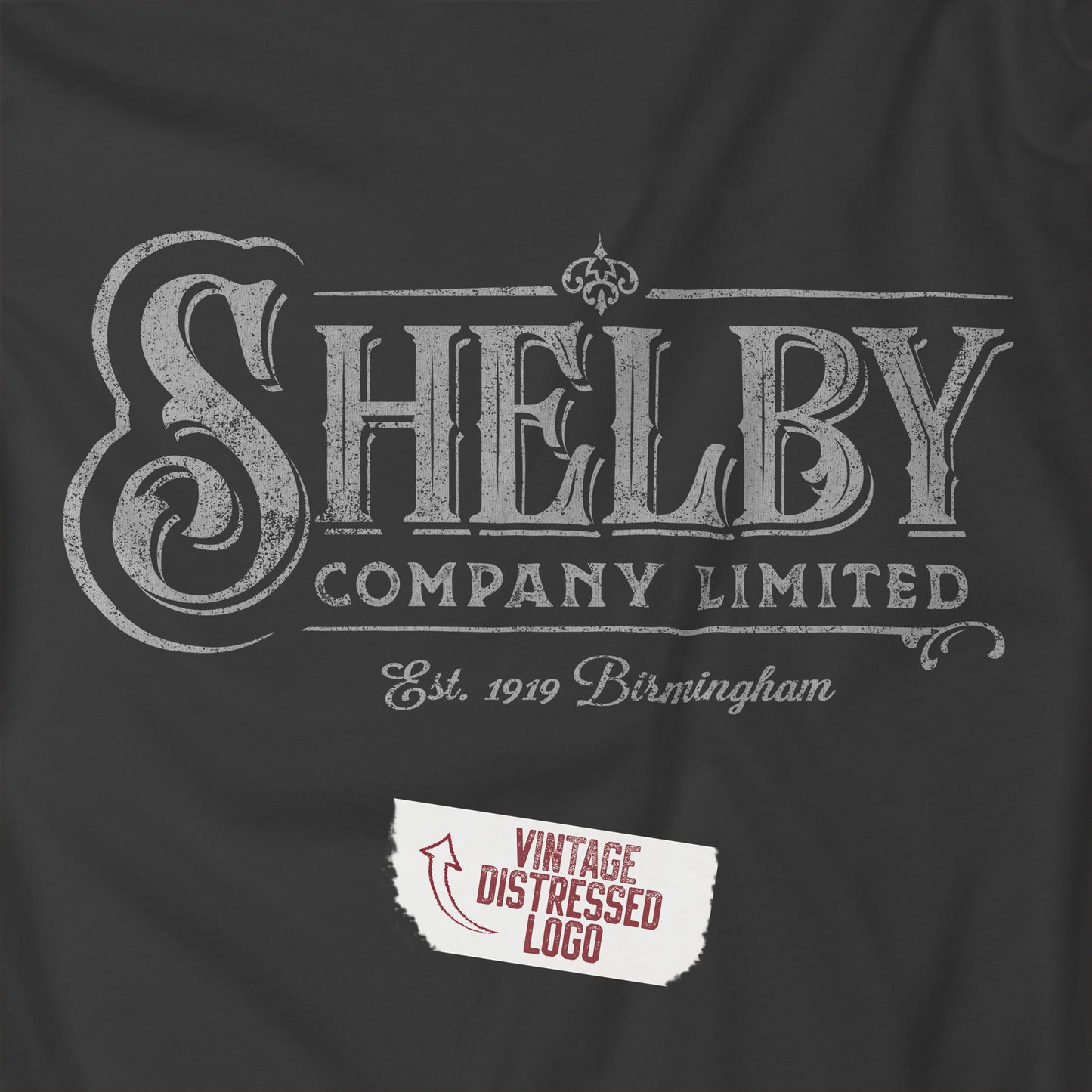 Closeup of an asphalt gray soft short-sleeve Bella+Canvas 3001 t-shirt featuring the Shelby Company Limited logo graphic from the show Peaky Blinders in a vintage distressed style, sold by ScriptedBrand.