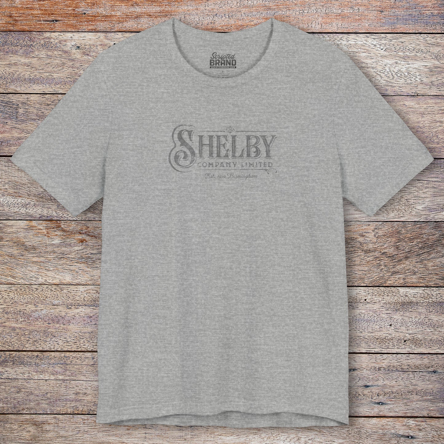 Front view of a athletic heather gray soft short-sleeve Bella+Canvas 3001 t-shirt featuring the Shelby Company Limited logo from the show Peaky Blinders in a vintage distressed style, sold by ScriptedBrand.
