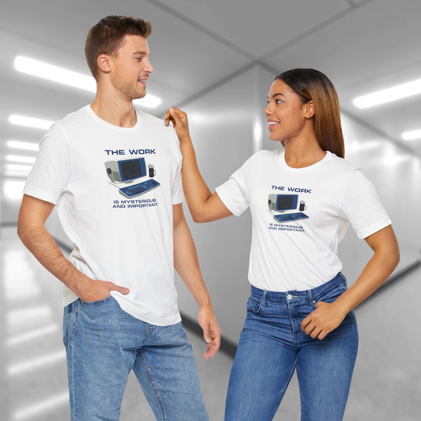 2 models wearing white Soft Bella+Canvas shirtsleeve t-shirts featuring the retro computer workstation from the Apple TV show Severance, and includes the text The Work is Mysterious and Important. Graphic is designed and illustrated by ScriptedBrand.