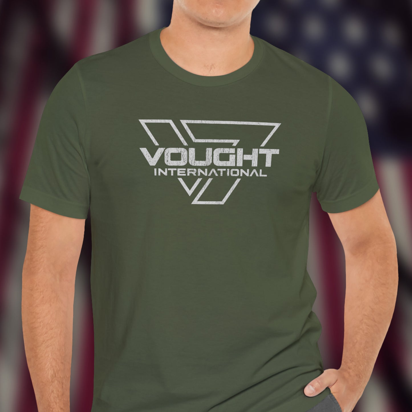 Male model wearing a military green soft Bella+Canvas 3001 short-sleeve t-shirt featuring the logo graphic of the fictional company Vought International inspired by the TV show The Boys in a vintage distressed style, sold by ScriptedBrand.