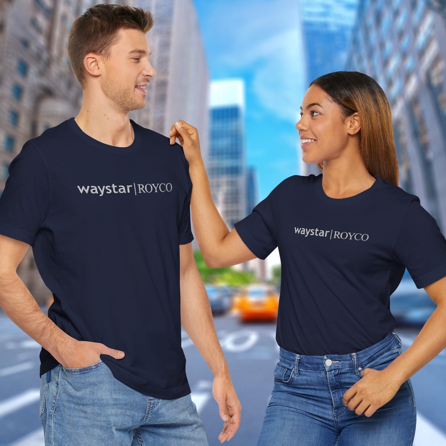 2 models wearing navy blue colored soft Bella+Canvas 3001 short-sleeve t-shirts featuring the Waystar Royco logo from the TV show Succession in a vintage distressed style, sold by ScriptedBrand.