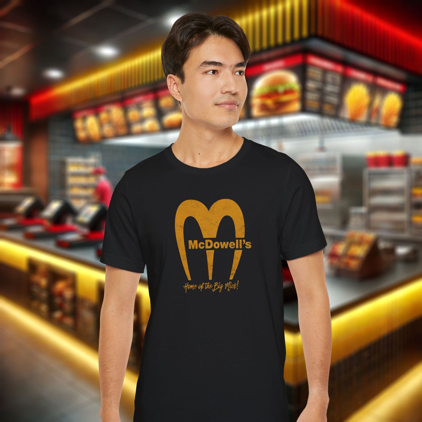 Man wearing a black t-shirt featuring the McDowells logo from the movie Coming to America in a vintage distressed style.