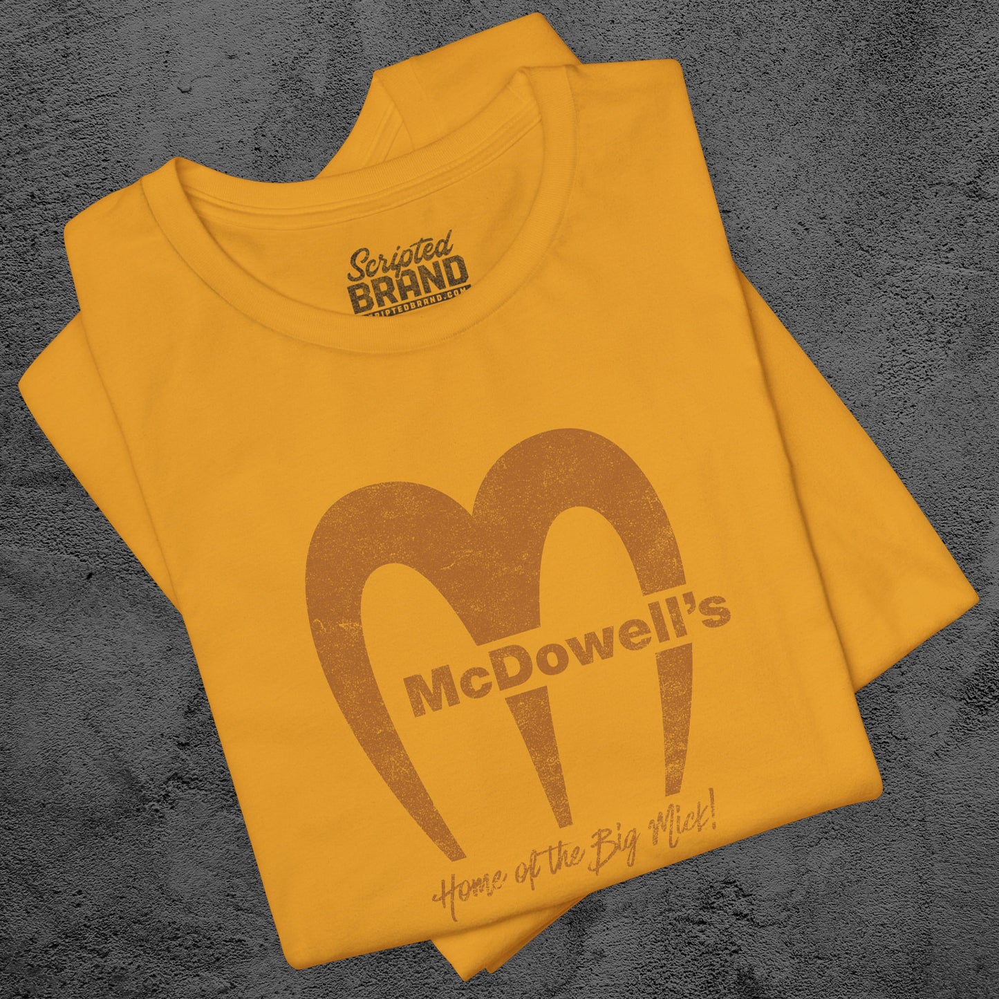 Mustard Gold t-shirt featuring the McDowells logo from the movie Coming to America in a vintage distressed style.