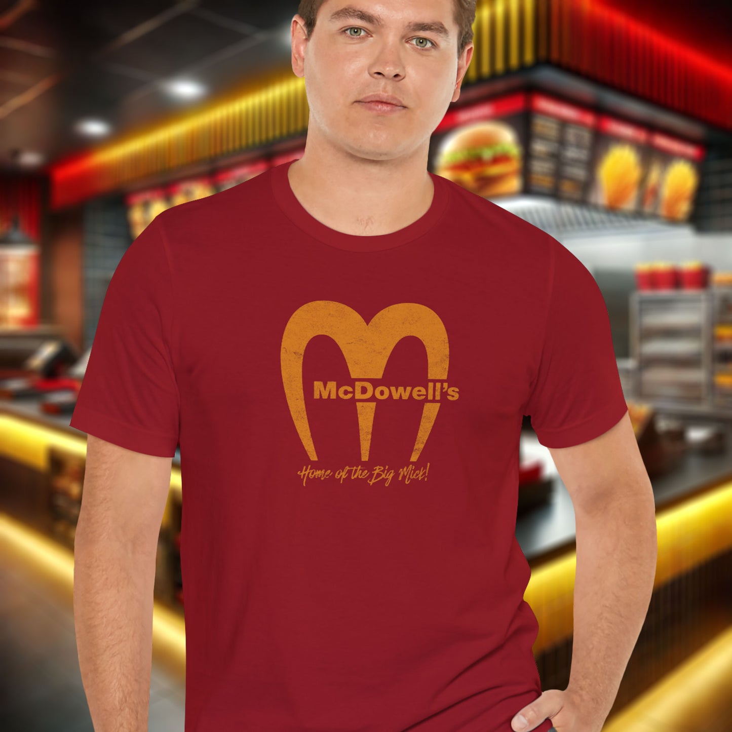Man wearing a red t-shirt featuring the McDowells logo from the movie Coming to America in a vintage distressed style.