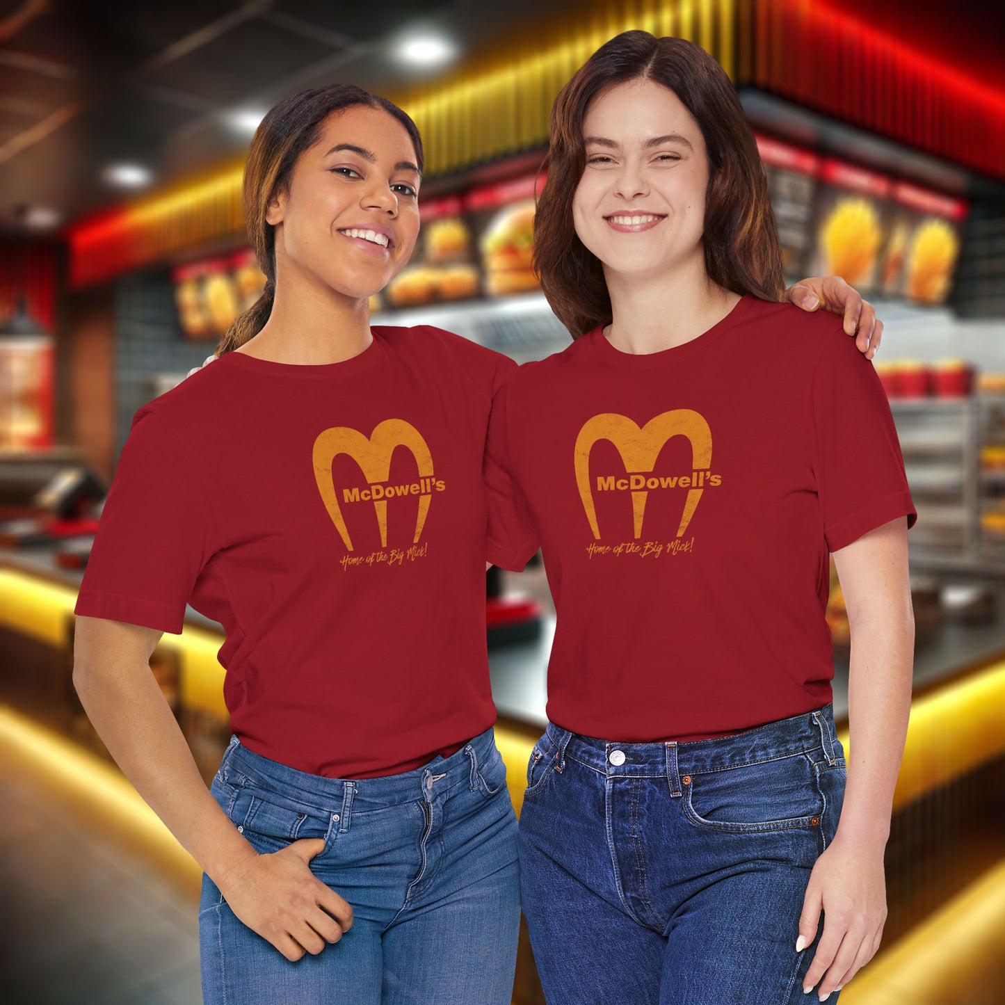 2 women wearing red t-shirts featuring the McDowells logo from the movie Coming to America in a vintage distressed style.
