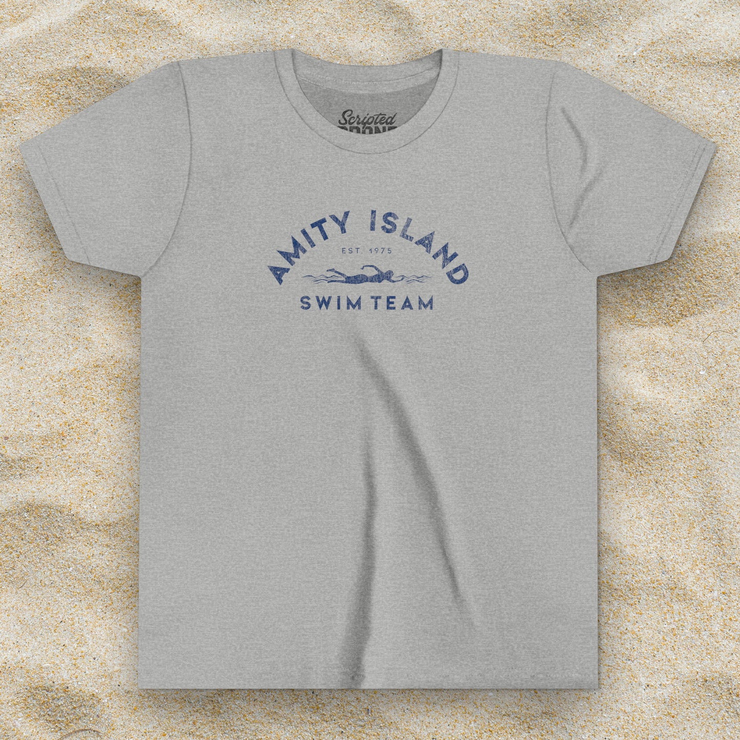 Front view of an Athletic Heather grey colored Soft unisex Youth Sizes Bella+Canvas 3001Y short-sleeve t-shirt featuring an Amity Island Swim Team logo graphic, designed by ScriptedBrand, and inspired by the movie Jaws in a vintage distressed style.