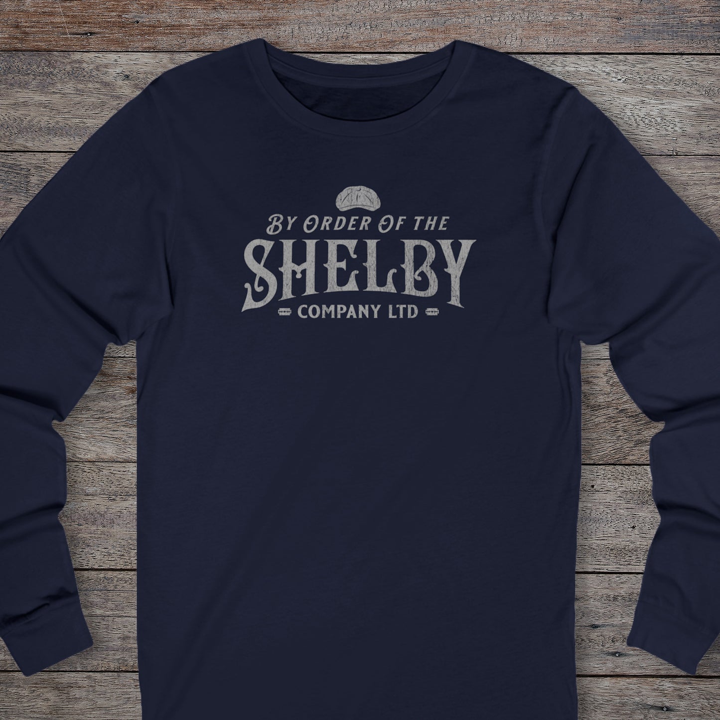 Front view of a navy blue Shelby Company Ltd long-sleeve tee with vintage logo from Peaky Blinders, featuring flat cap and razor blades.