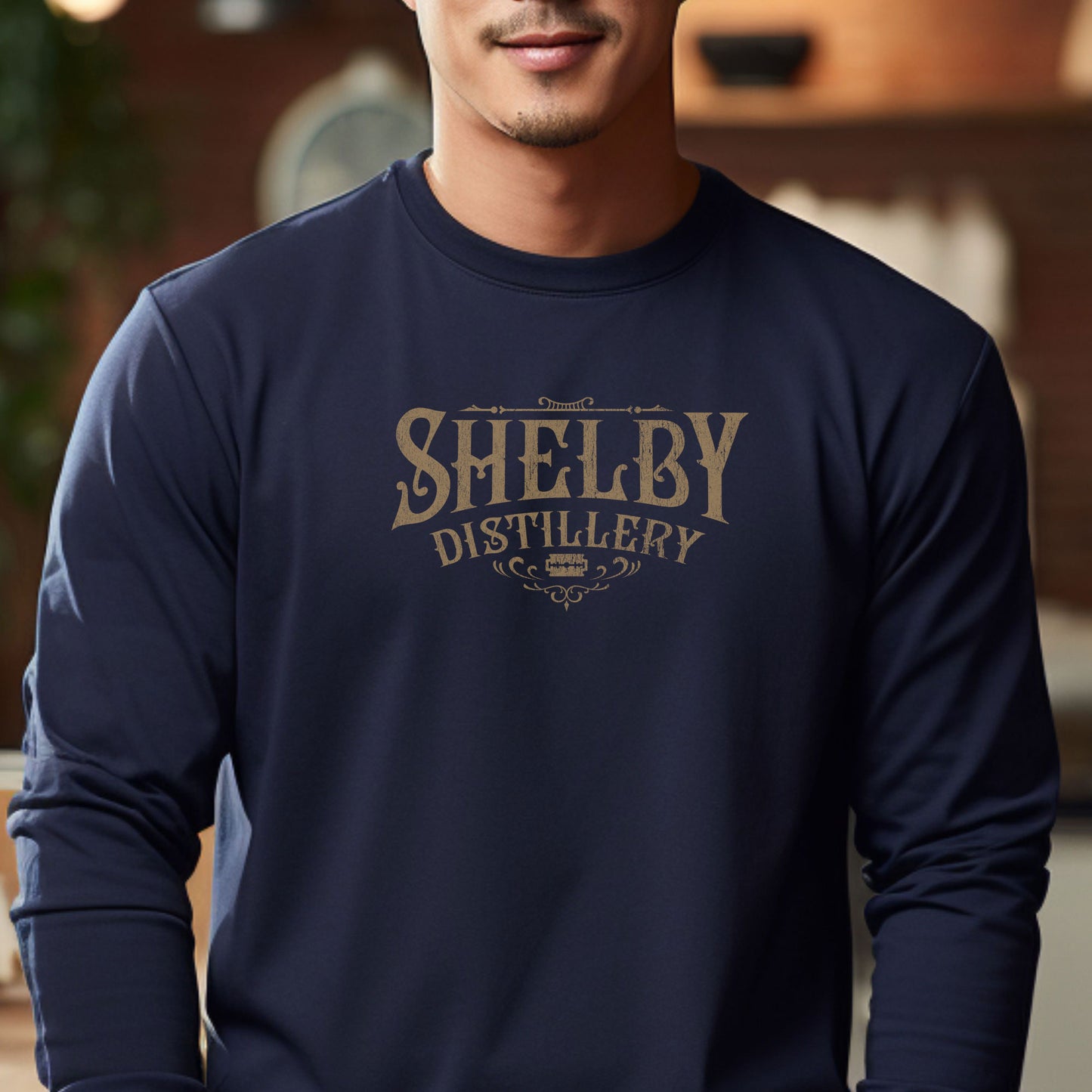 Male model wearing a navy blue Soft Unisex Bella+Canvas 3501 long-sleeve t-shirt featuring a Shelby Company Limited Distillery Logo Graphic inspired by the TV show Peaky Blinders in a vintage distressed style, sold by ScriptedBrand.