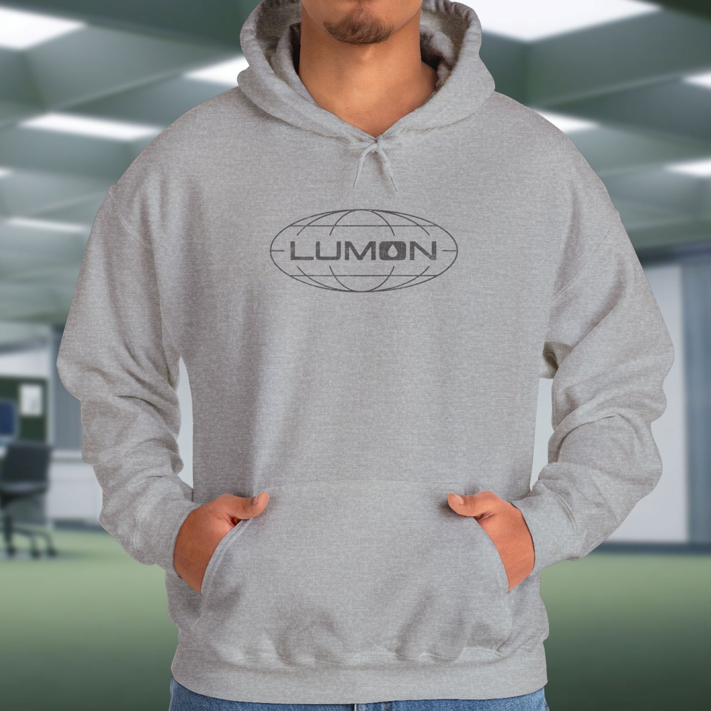 Model wearing a Sport Heather Gray colored Soft Unisex Heavy Blend Hooded Sweatshirt featuring the fictional Lumon Industries logo from the Apple TV show Severance.