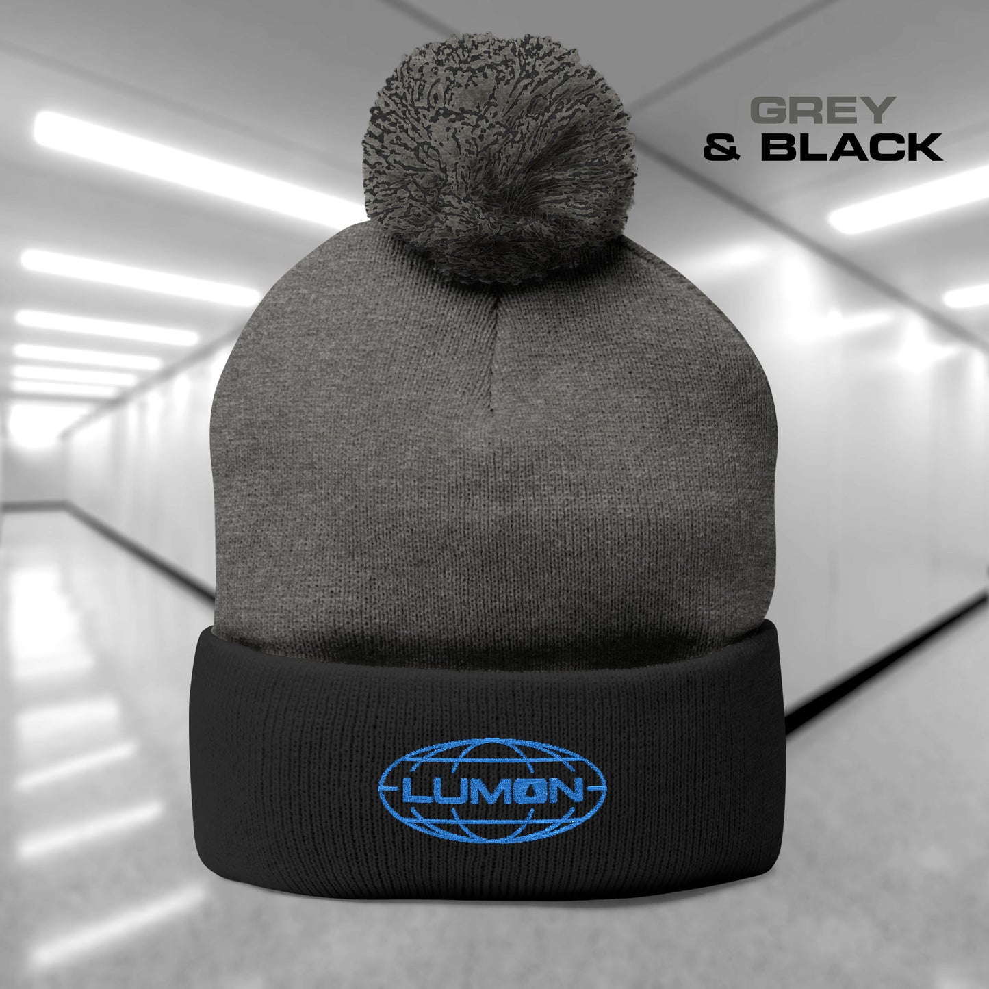 Gray and Black colored Pom-Pom Winter Knit Hat featuring the embroidered blue logo of Lumon Industries from the Apple TV Show Severance.