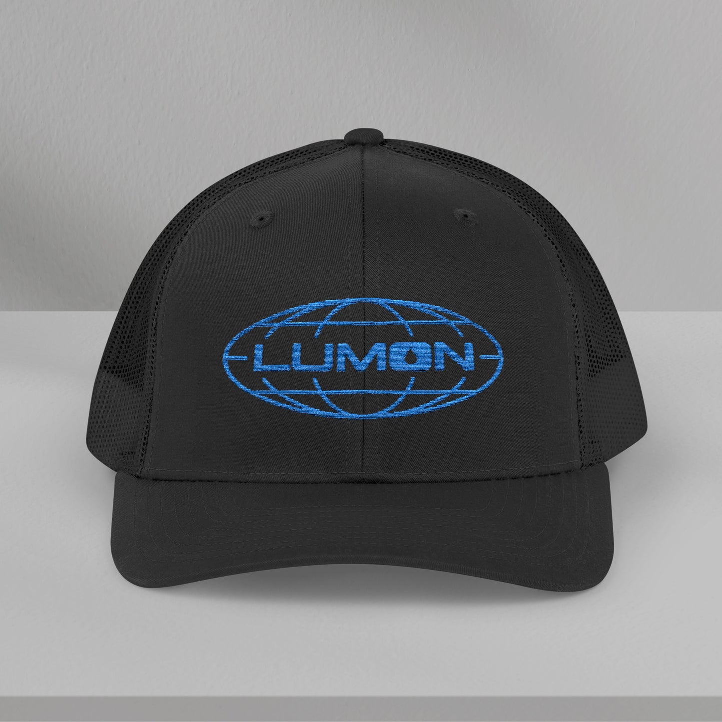 Front view of a black colored Embroidered Snapback Trucker Cap featuring the blue logo of Lumon Industries from the Apple TV Show Severance.