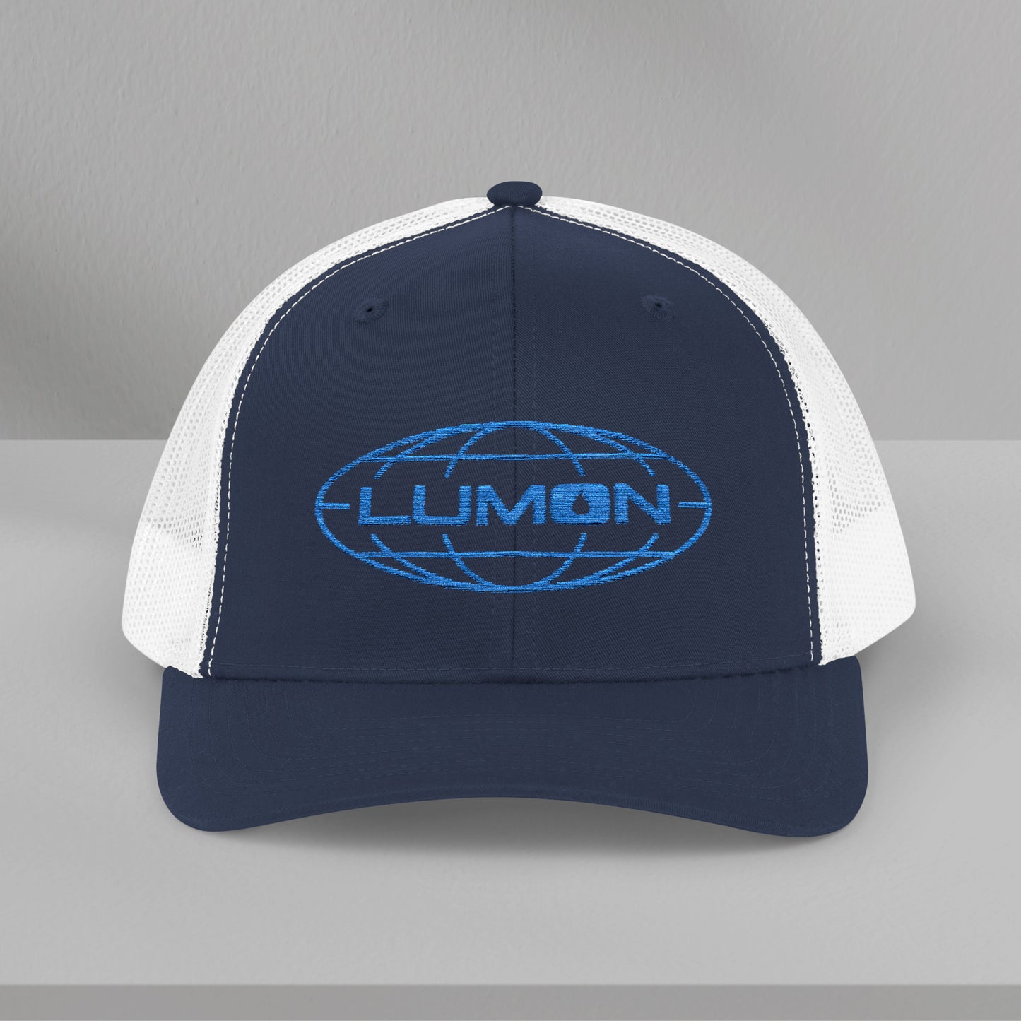 Front view of a navy/white Embroidered Snapback Trucker Cap featuring the blue logo of Lumon Industries from the Apple TV Show Severance.