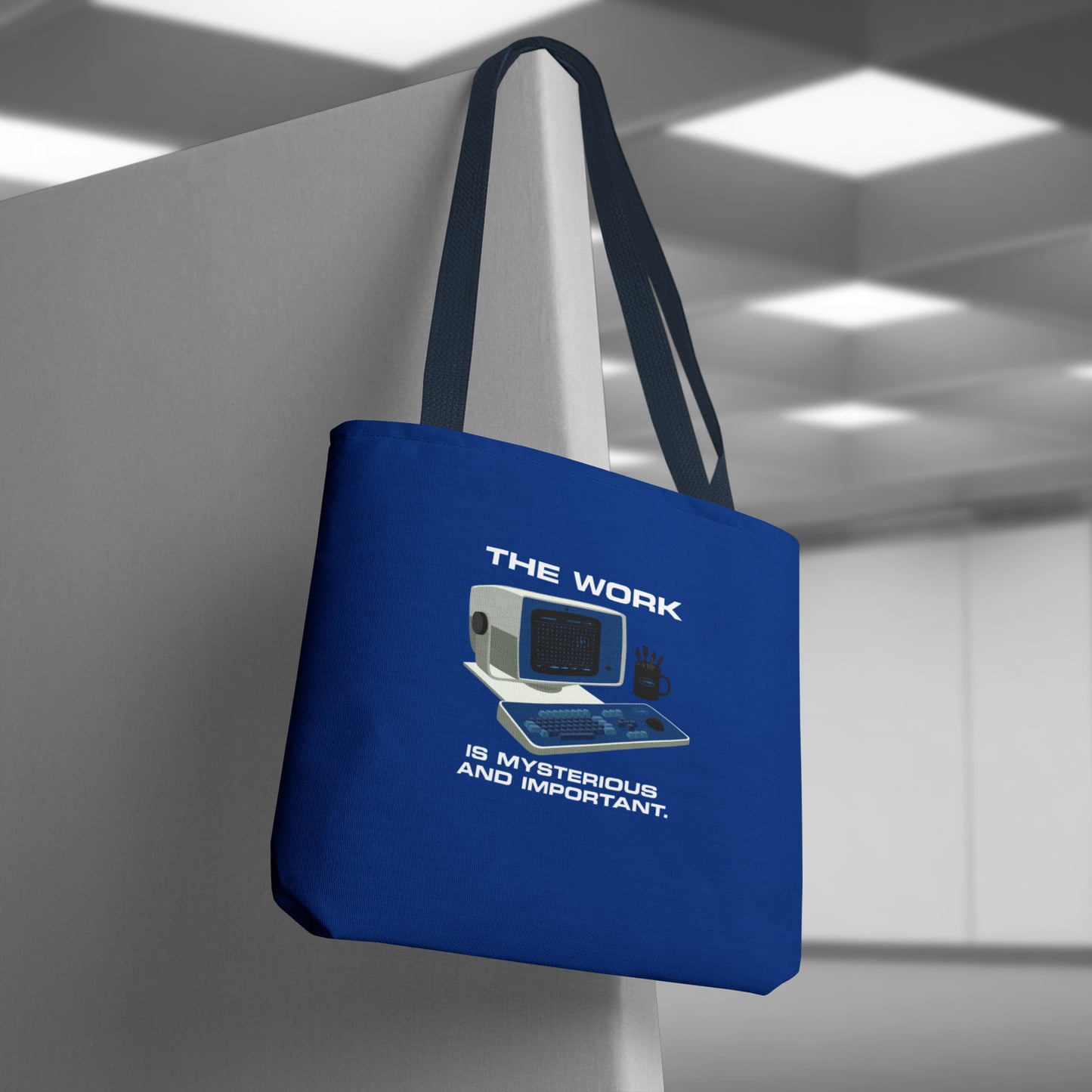 Hanging Blue Tote Bag featuring the retro computer workstation from the Apple TV show Severance, and includes the text The Work is Mysterious and Important. Graphic is designed and illustrated by ScriptedBrand.