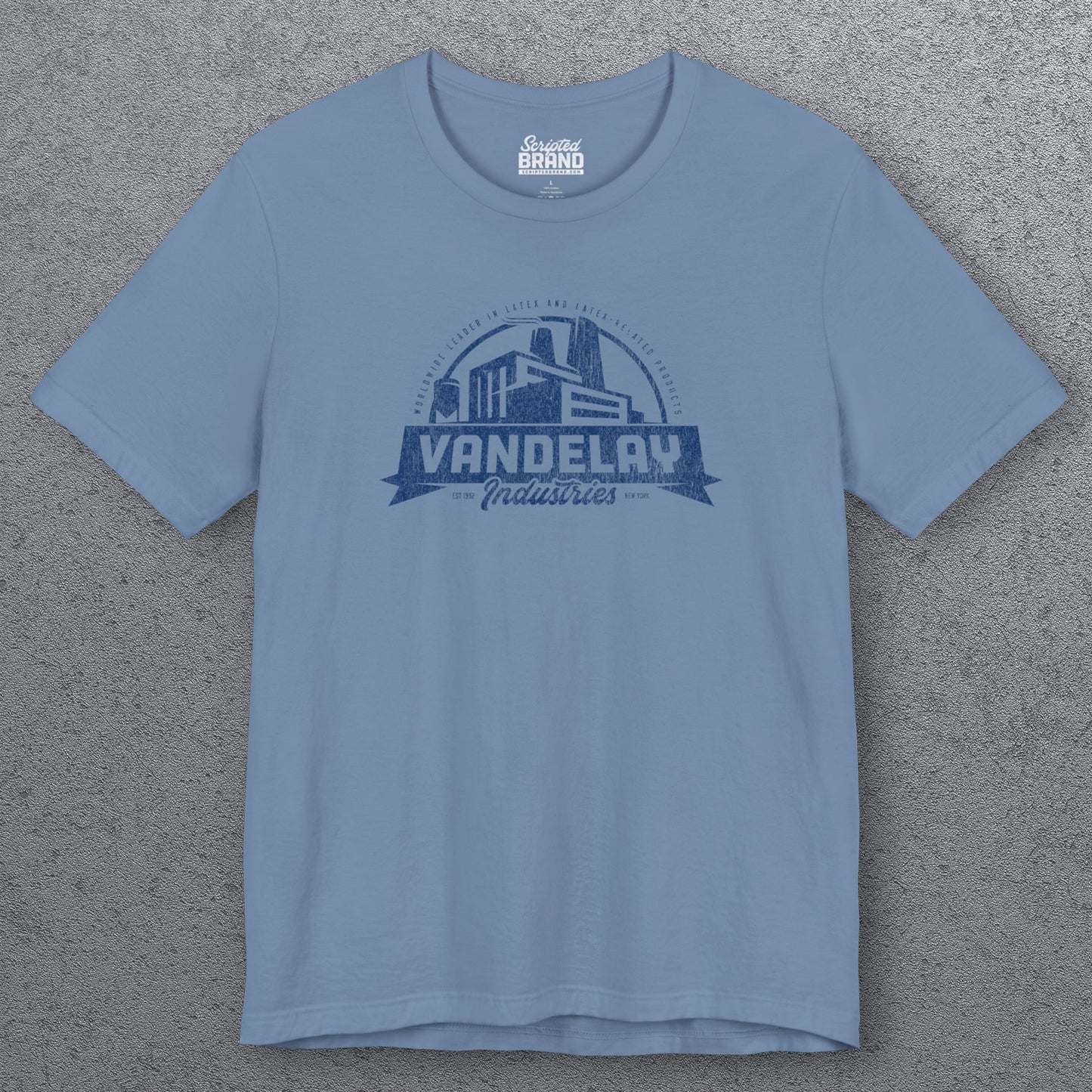 Front view of a steel blue Soft Bella+Canvas 3001 short-sleeve t-shirt tee featuring a Vandelay Industries logo graphic, uniquely designed by ScriptedBrand in a vintage distressed style. The fictional company is part of the George Costanza storyline in the TV show Seinfeld.