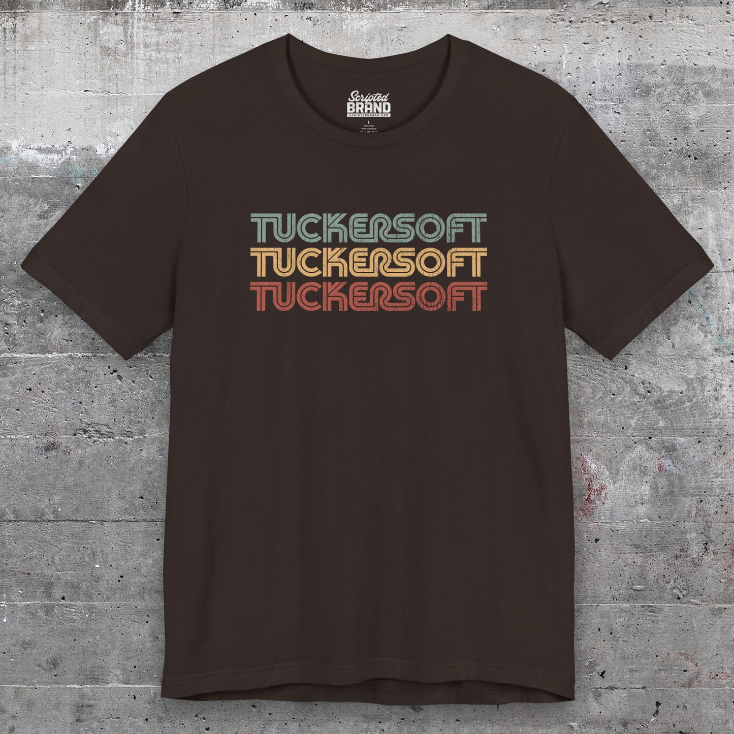 Front view of a brown soft Bella+Canvas 3001 short-sleeve t-shirt tee featuring a logo graphic of the 1980s fictional video game company Tuckersoft inspired by the TV show Black Mirror and the episode Bandersnatch in a vintage distressed style, sold by ScriptedBrand.