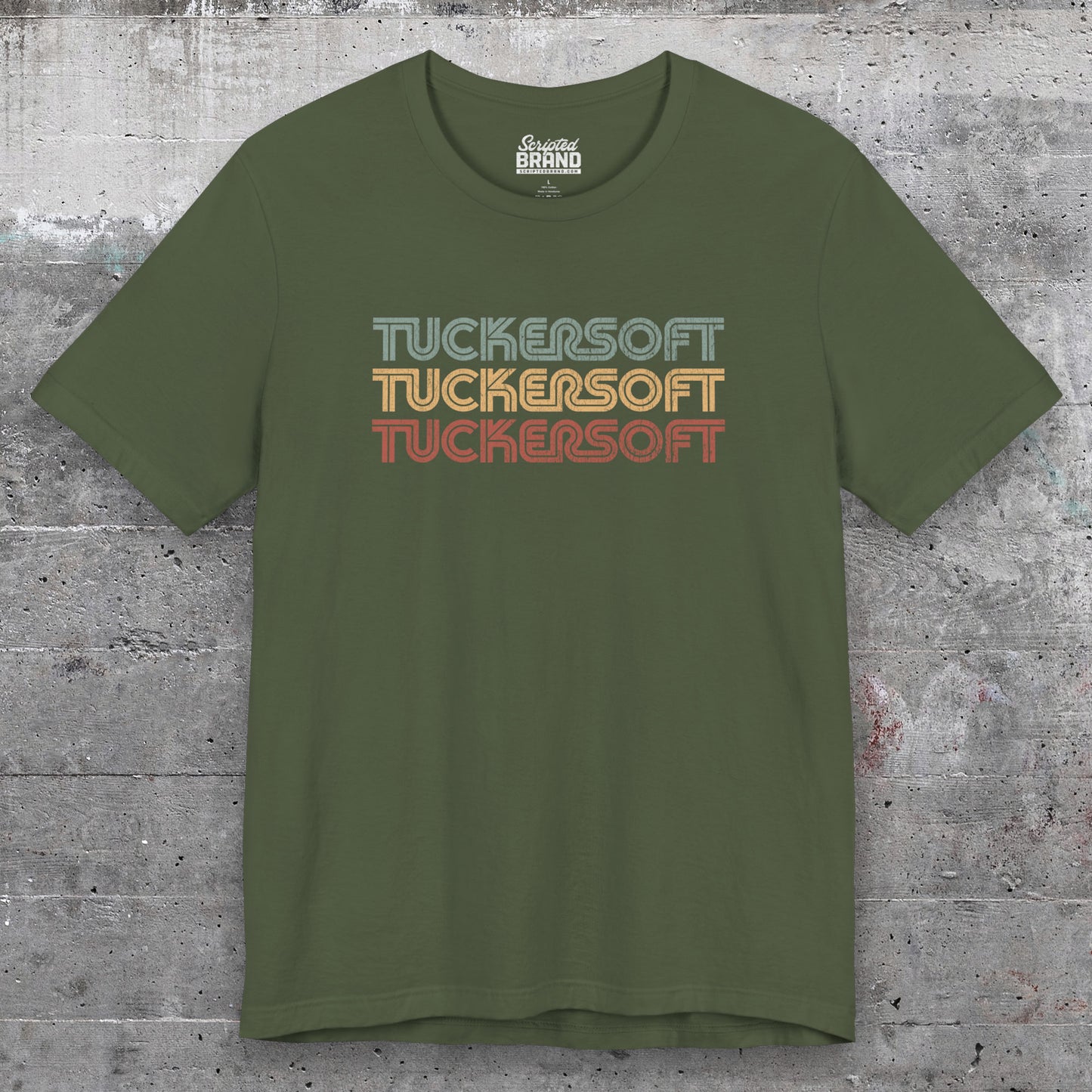 Front view of a military green soft Bella+Canvas 3001 short-sleeve t-shirt tee featuring a logo graphic of the 1980s fictional video game company Tuckersoft inspired by the TV show Black Mirror and the episode Bandersnatch in a vintage distressed style, sold by ScriptedBrand.