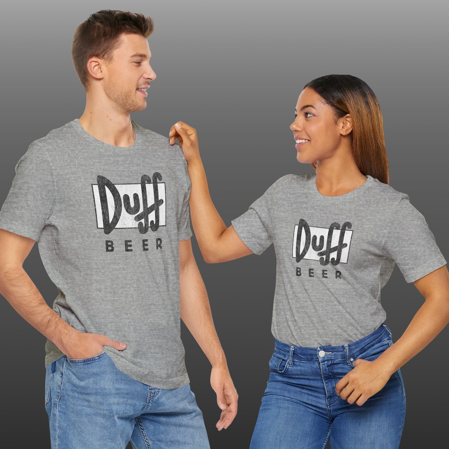 Two people wearing heather gray t-shirts featuring the Duff Beer logo from the TV Show The Simpsons in vintage distressed style.