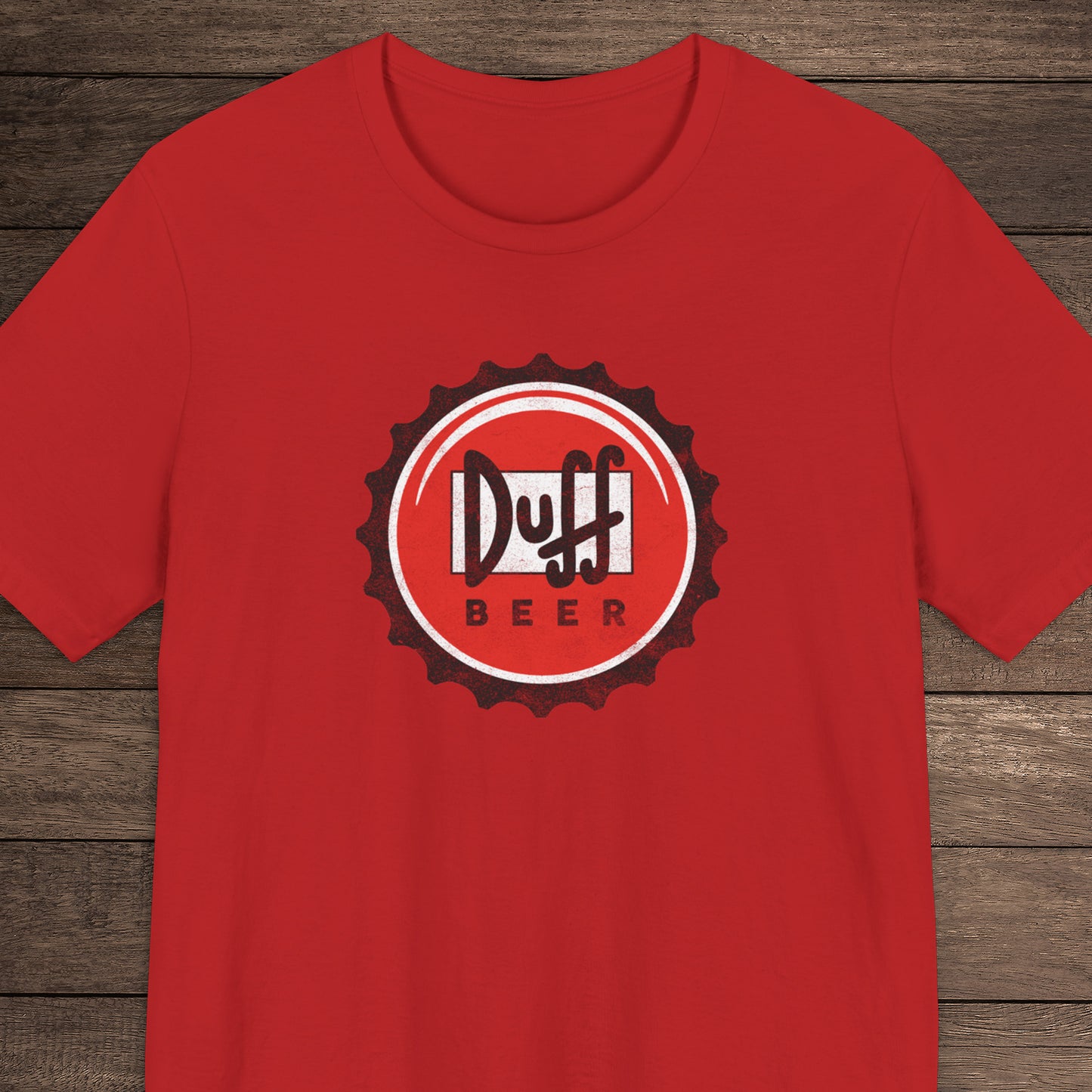 Red t-shirt featuring the Duff Beer bottle cap logo from the TV Show The Simpsons in vintage distressed style.