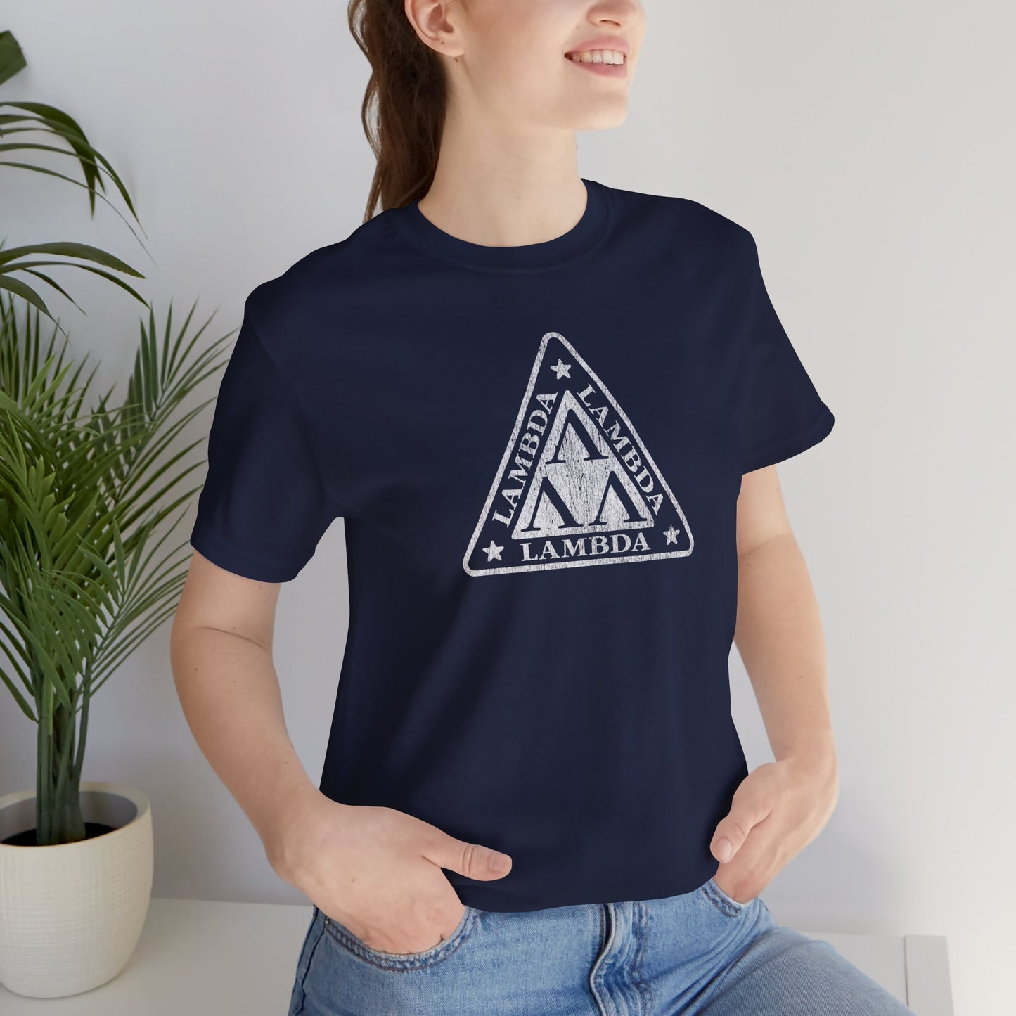 Female model wearing a navy blue colored Tri-Lam soft Bella+Canvas 3001 short-sleeve t-shirt featuring the logo graphic of the fictional fraternity Lambda Lambda Lambda, inspired by the movie Revenge of the Nerds, printed in a vintage distressed style, sold by ScriptedBrand.