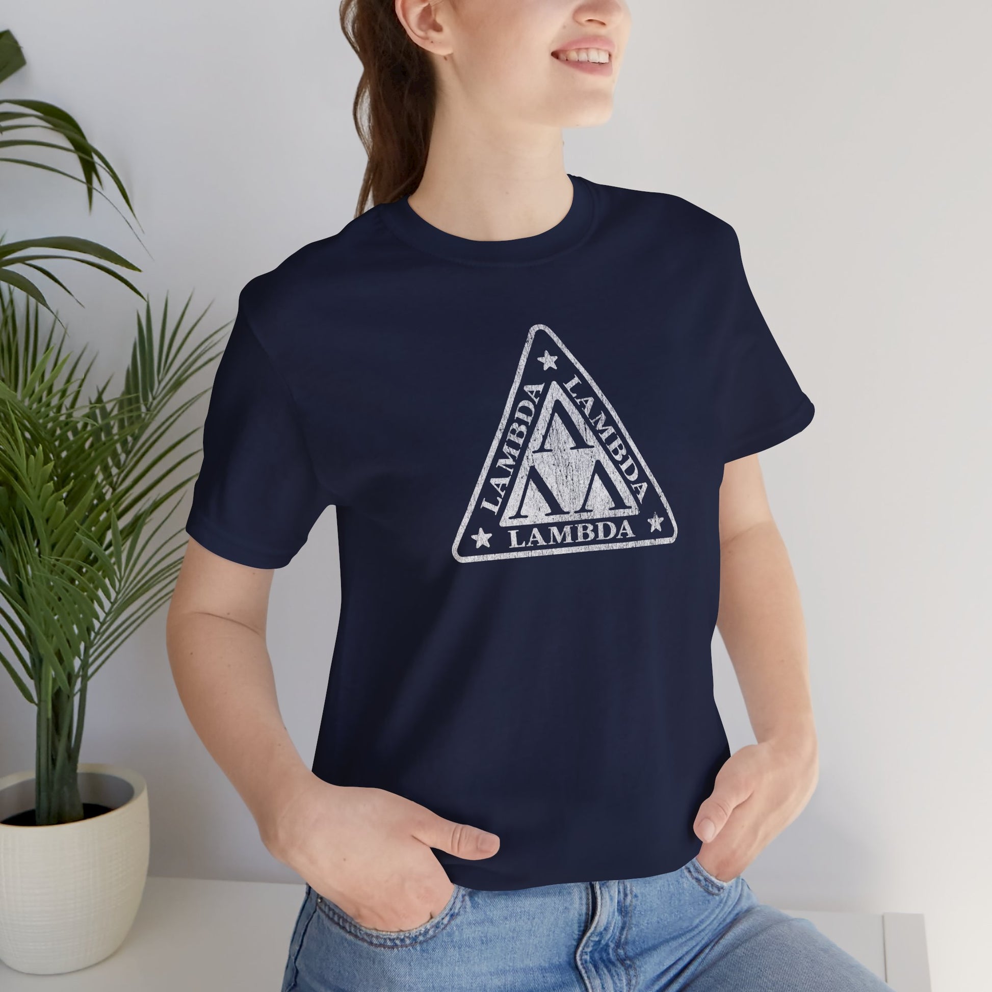 Female model wearing a navy blue colored Tri-Lam soft Bella+Canvas 3001 short-sleeve t-shirt featuring the logo graphic of the fictional fraternity Lambda Lambda Lambda, inspired by the movie Revenge of the Nerds, printed in a vintage distressed style, sold by ScriptedBrand.