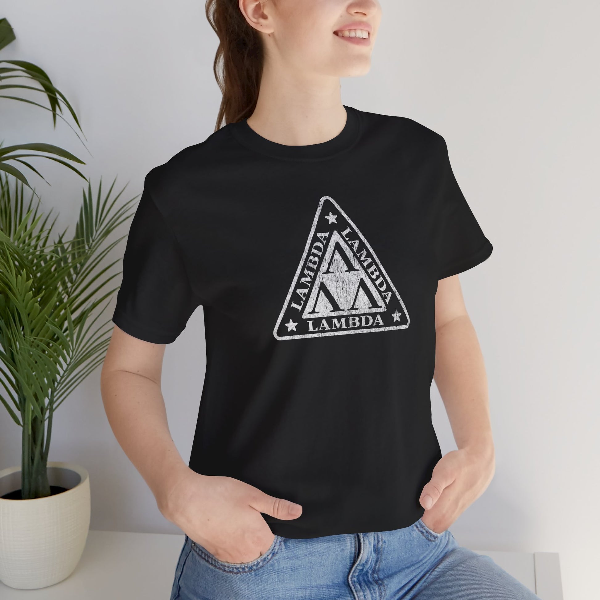 Female model wearing a black colored Tri-Lam soft Bella+Canvas 3001 short-sleeve t-shirt featuring the logo graphic of the fictional fraternity Lambda Lambda Lambda, inspired by the movie Revenge of the Nerds, printed in a vintage distressed style, sold by ScriptedBrand.