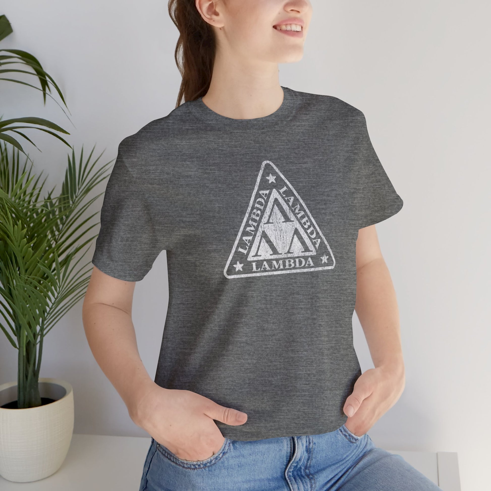 Female model wearing a deep heather colored Tri-Lam soft Bella+Canvas 3001 short-sleeve t-shirt featuring the logo graphic of the fictional fraternity Lambda Lambda Lambda, inspired by the movie Revenge of the Nerds, printed in a vintage distressed style, sold by ScriptedBrand.