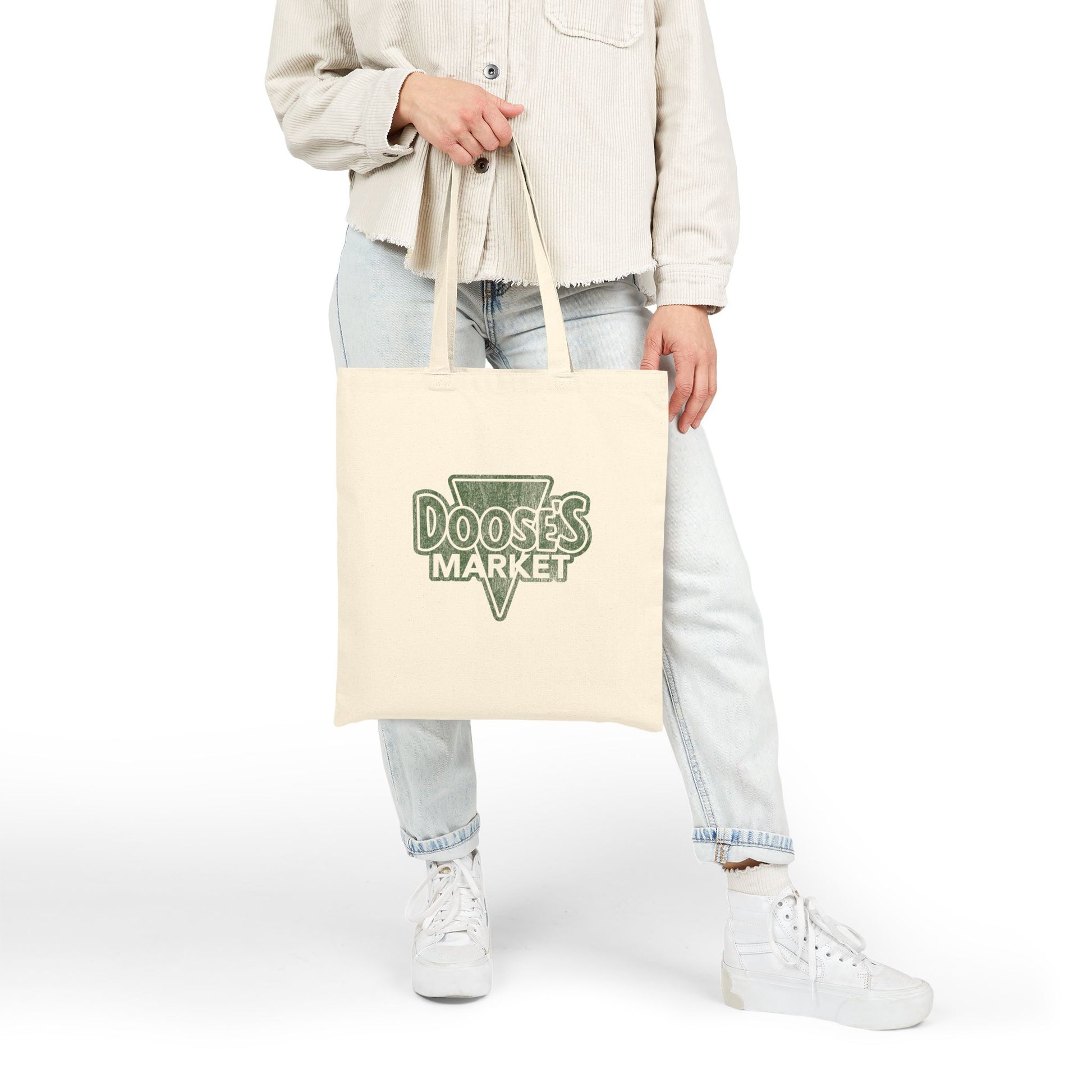 Person holding cotton canvas tote bag with vintage green Doose’s Market logo on both sides, inspired by Gilmore Girls.