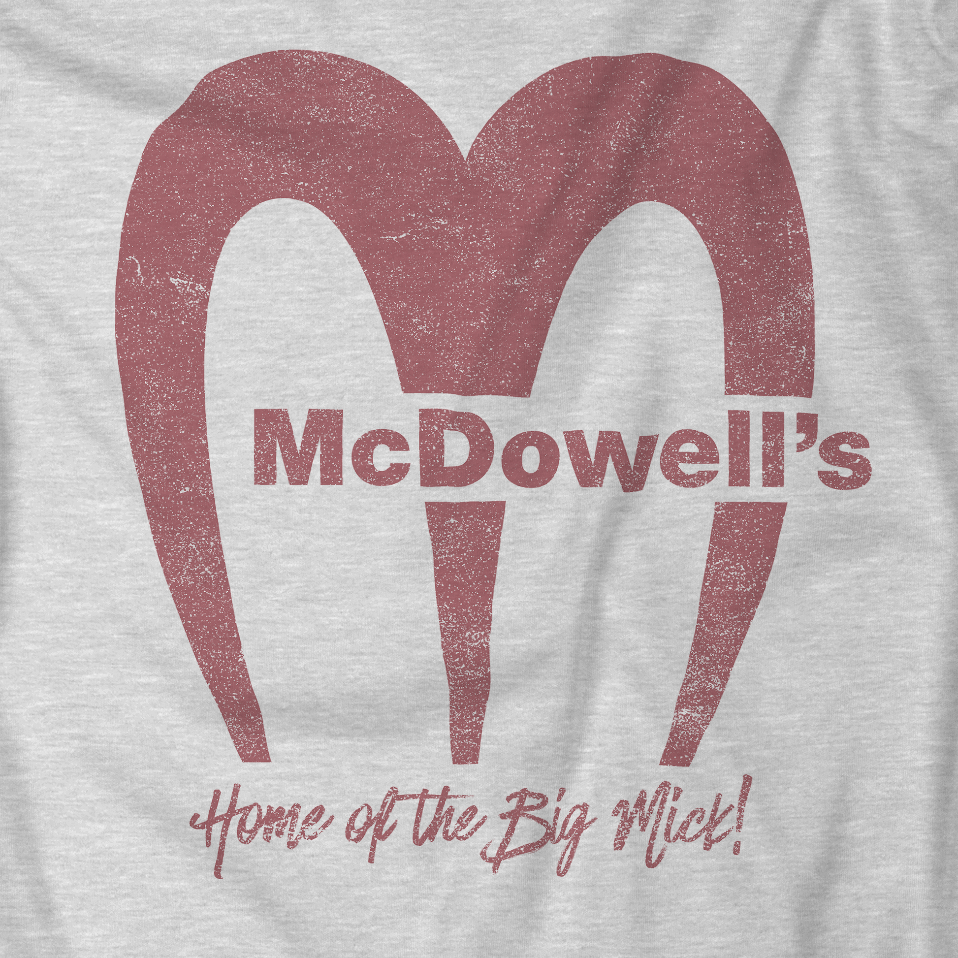 Closeup of Heather gray t-shirt featuring the McDowells logo from the movie Coming to America in a vintage distressed style.