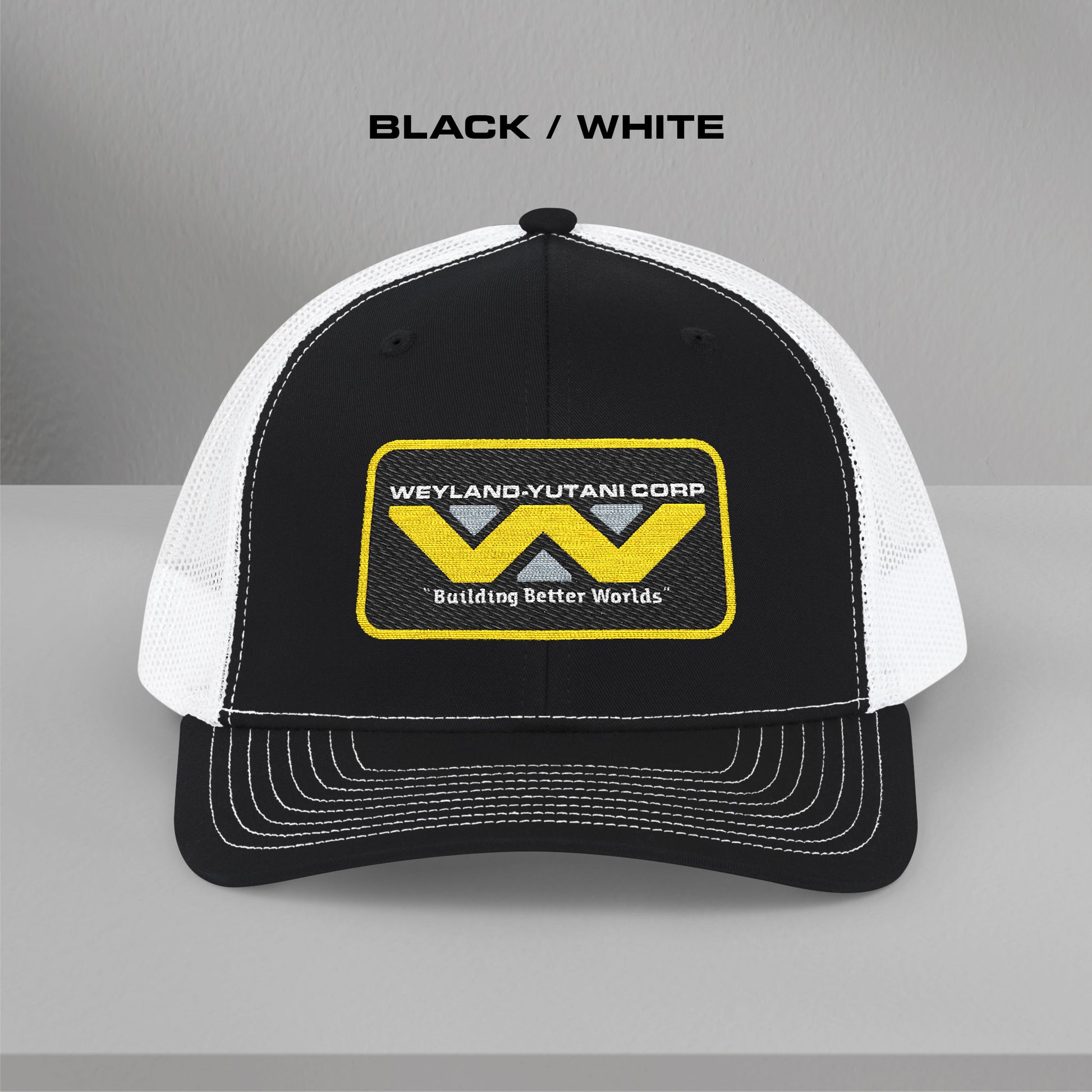 Front view of black-white Embroidered Snapback Trucker Cap with logo of Weyland-Yutani from the Alien movie franchise.