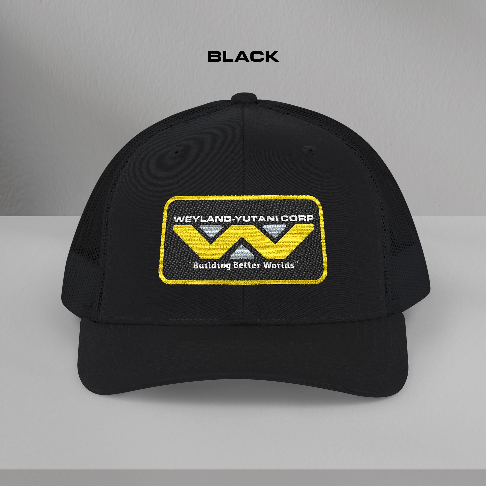 Front view of black Embroidered Snapback Trucker Cap with logo of Weyland-Yutani from the Alien movie franchise.