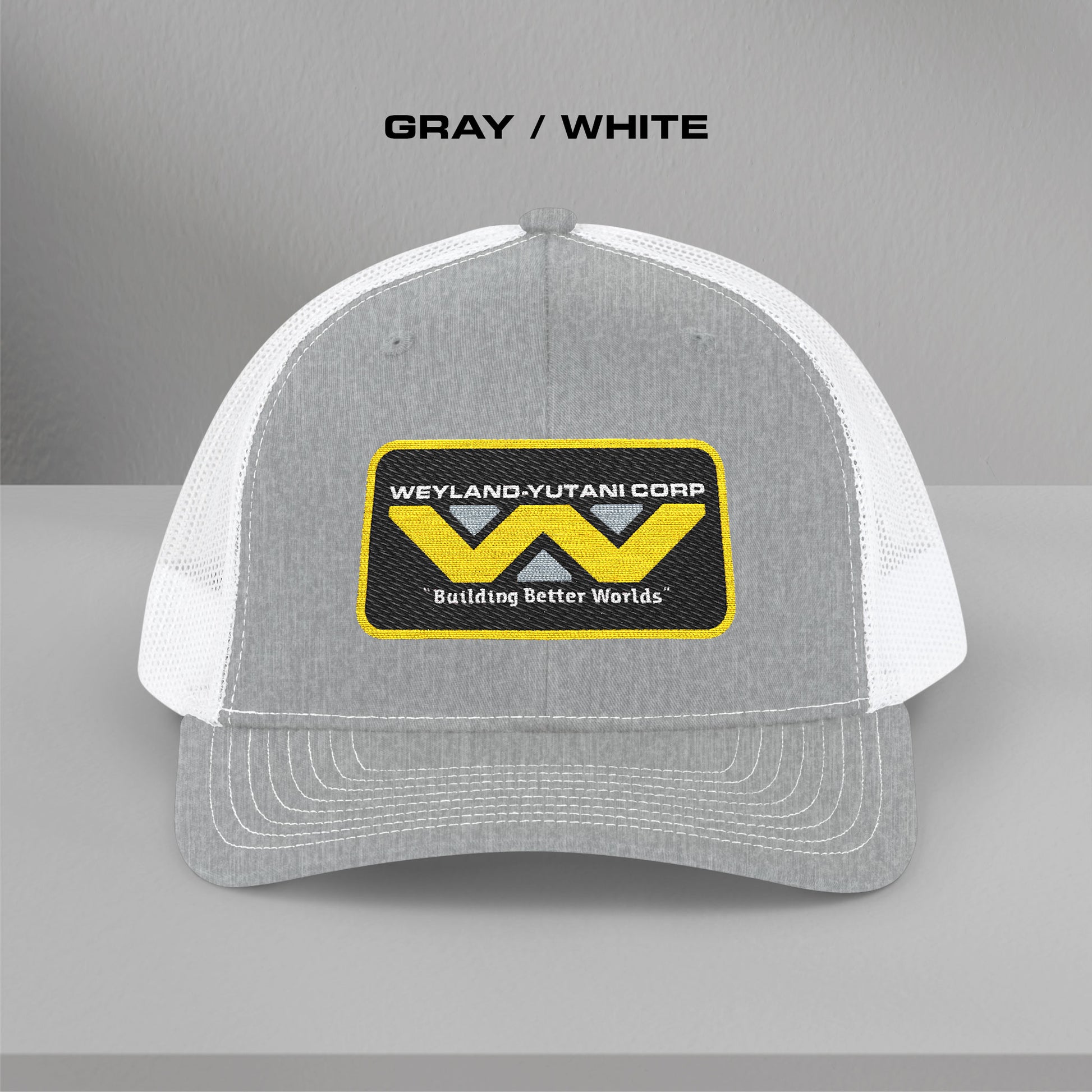 Front view of gray-white Embroidered Snapback Trucker Cap with logo of Weyland-Yutani from the Alien movie franchise.