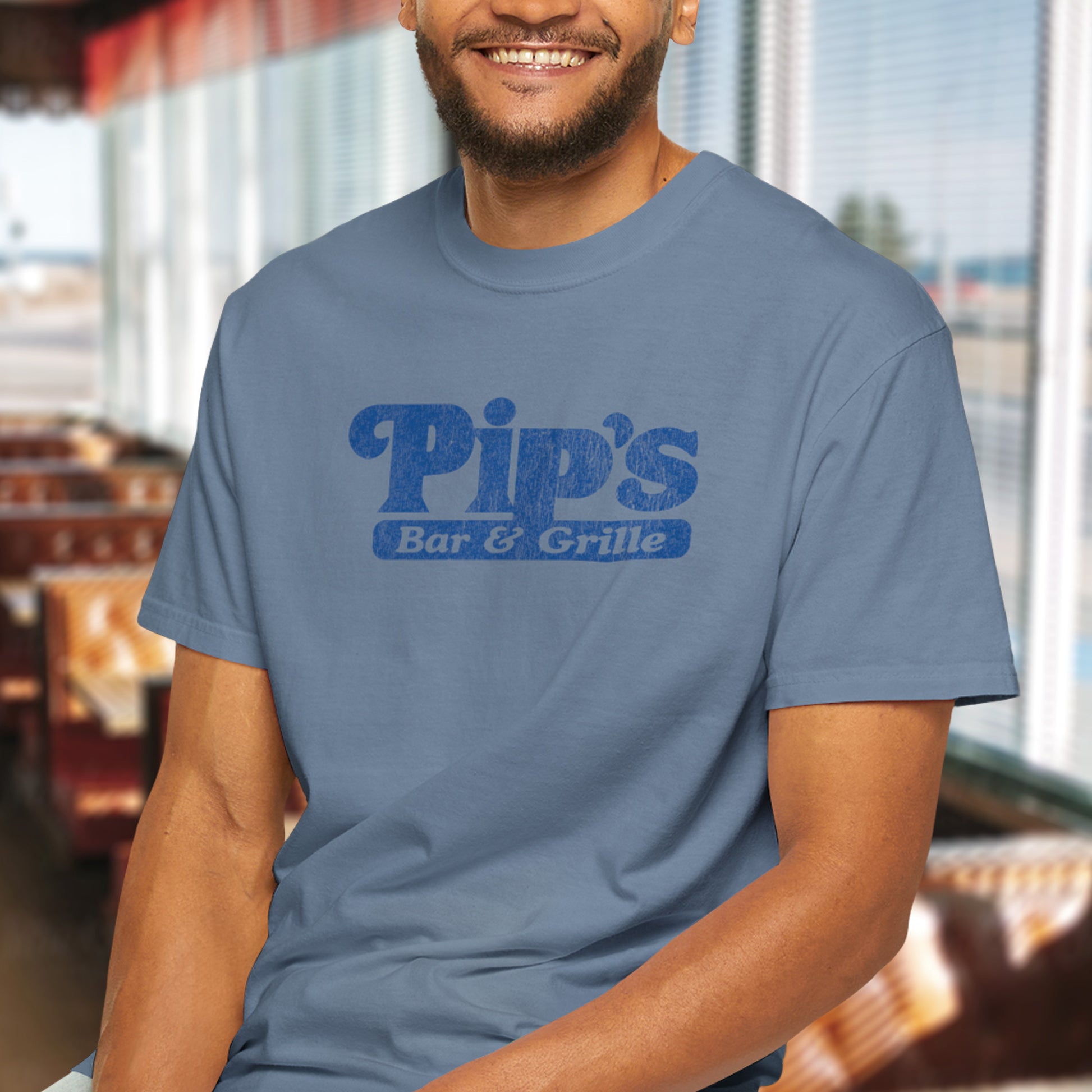 Male wearing Vintage-style Pip’s Bar & Grill t-shirt from Severance on Comfort Colors 1717 with distressed logo.